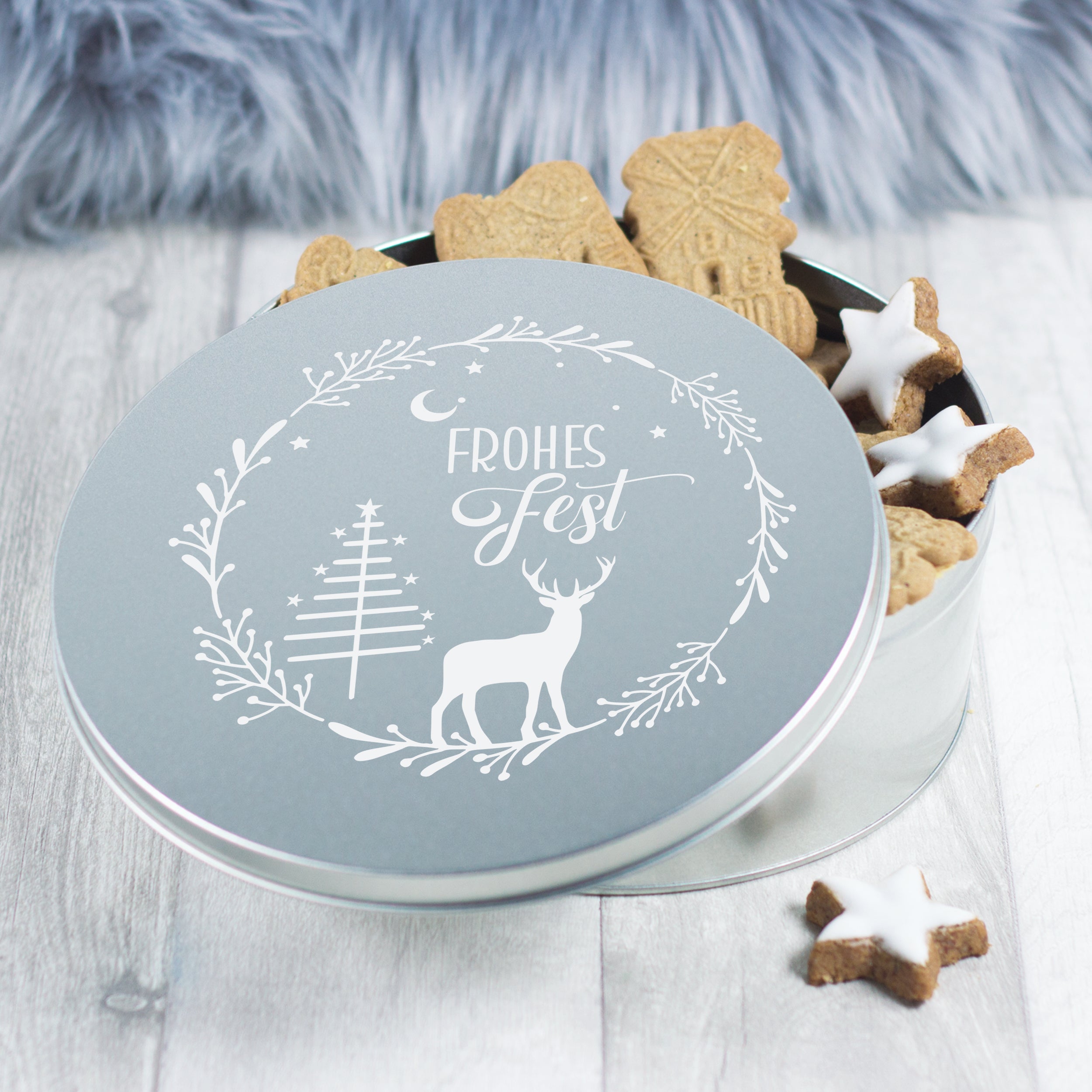 Keksdose in Silber mit Weihnachtsmotiv und Plätzchen.