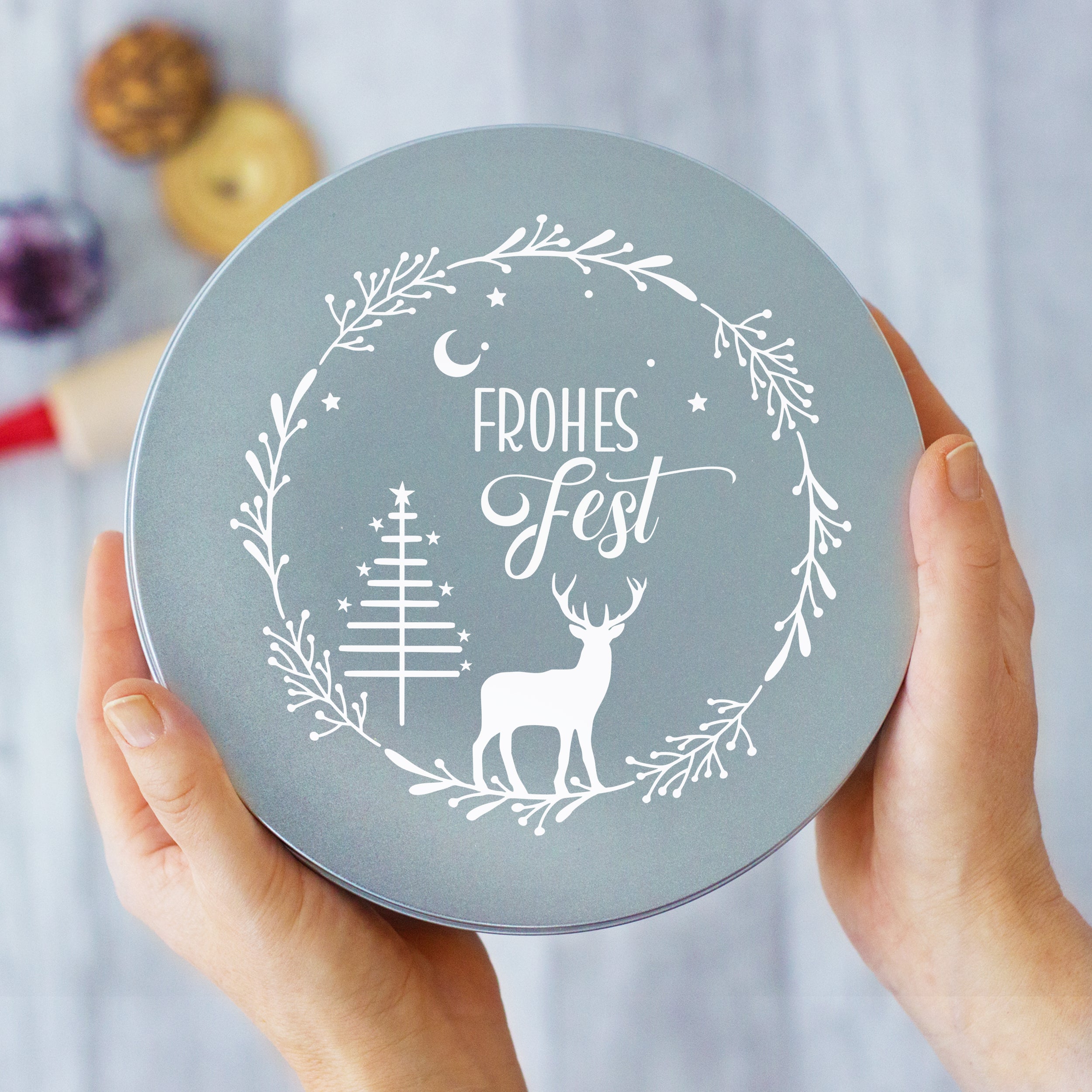 Graue Dose mit weißem Weihnachtsdesign und "Frohes Fest"