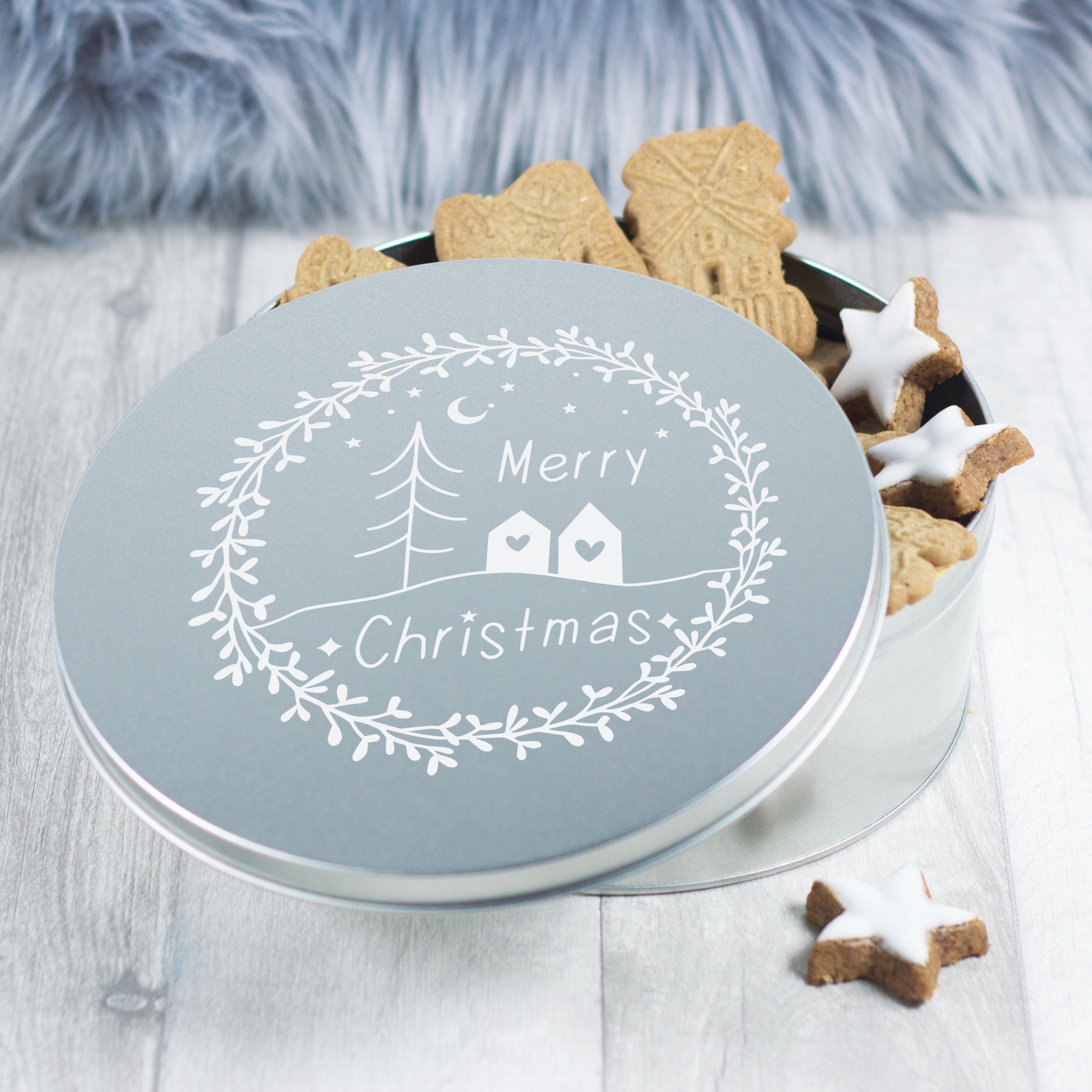 Silberne Keksdose mit Weihnachtsmotiv und Lebkuchen.