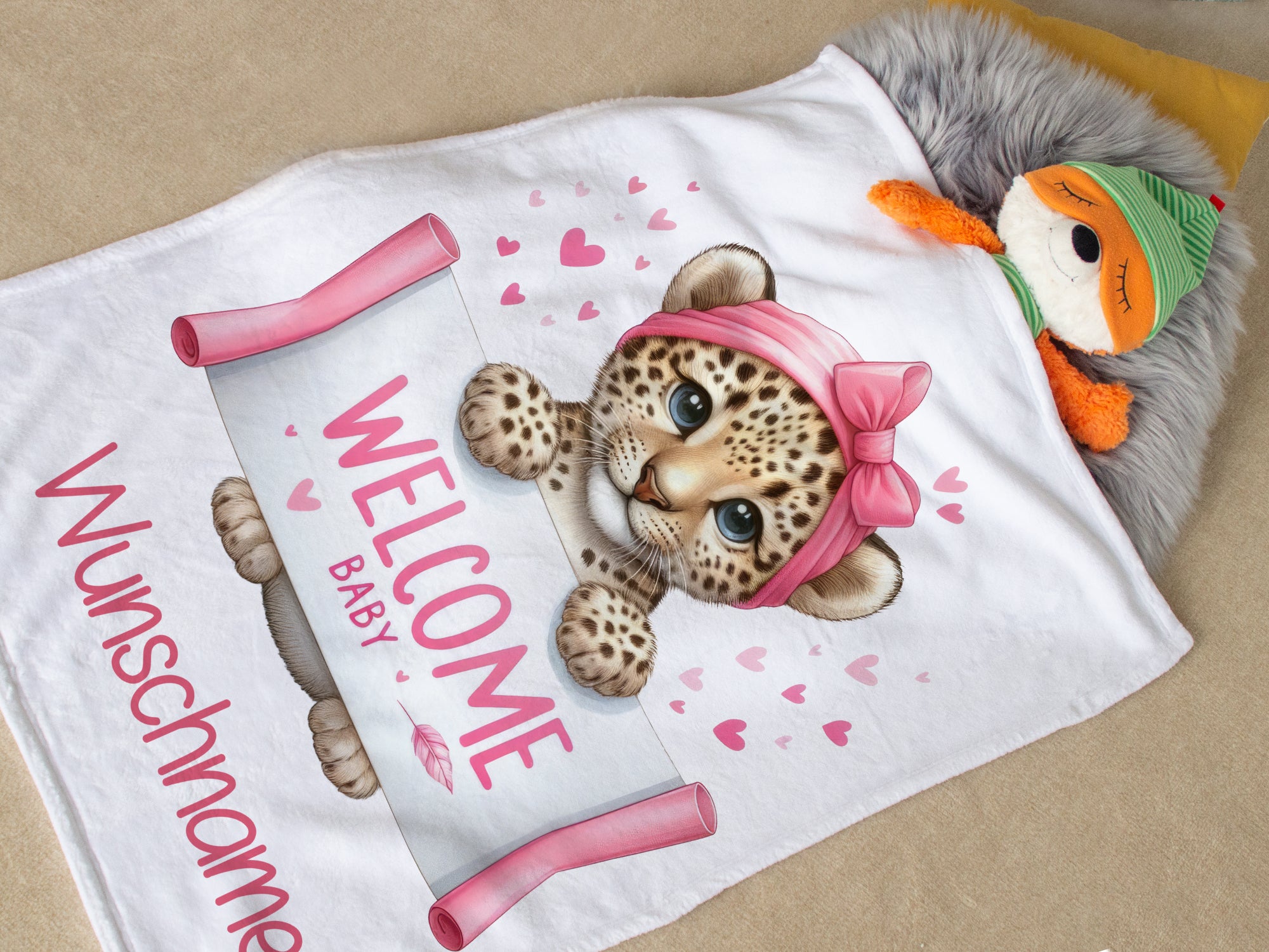 Willkommensdecke mit Leopardenmotiv und rosa Schleife.