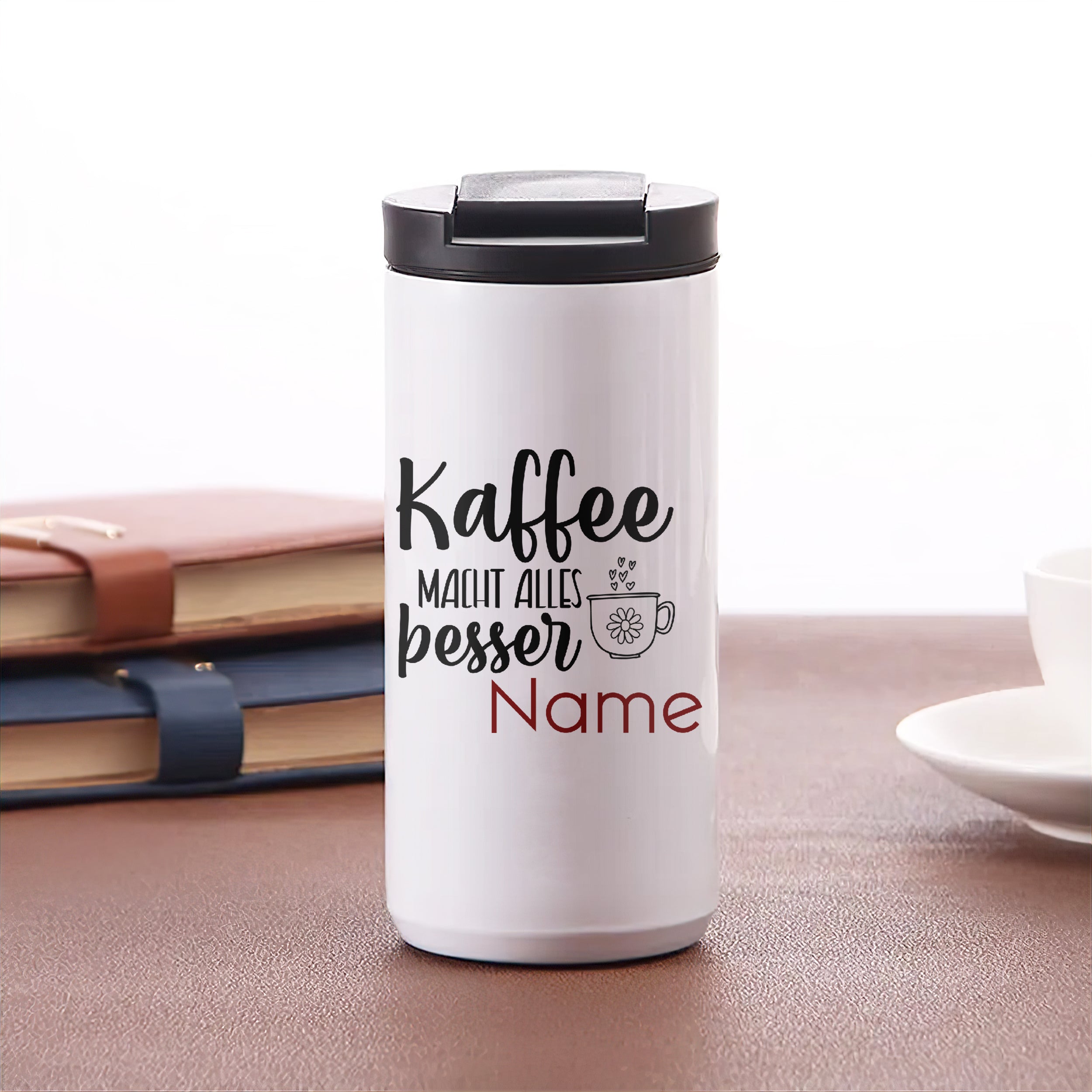 Weißer Kaffeebecher mit schwarzem Deckel und personalisiertem Text.