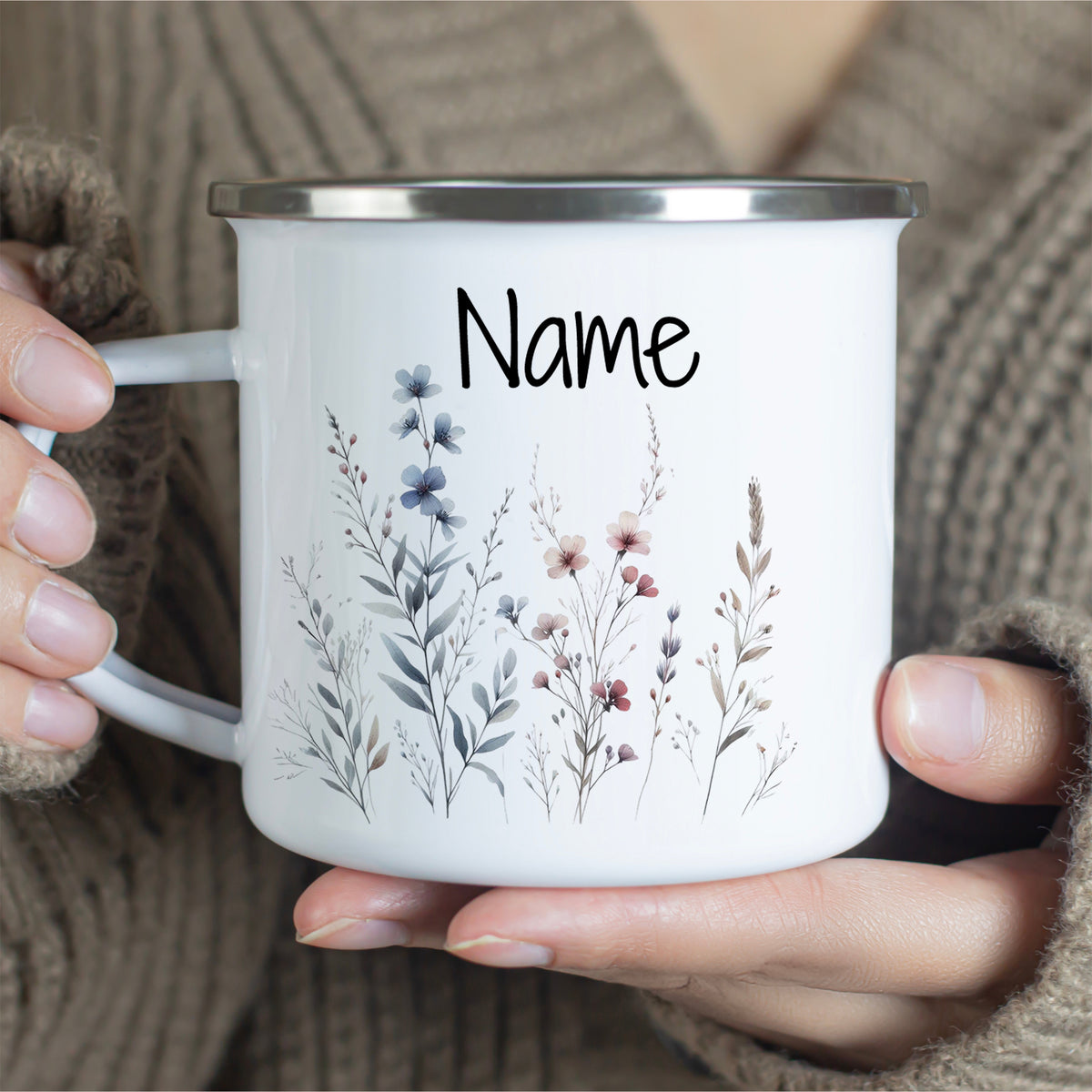 Weißer Emaillebecher mit floralem Design und personalisierbarem Namen.