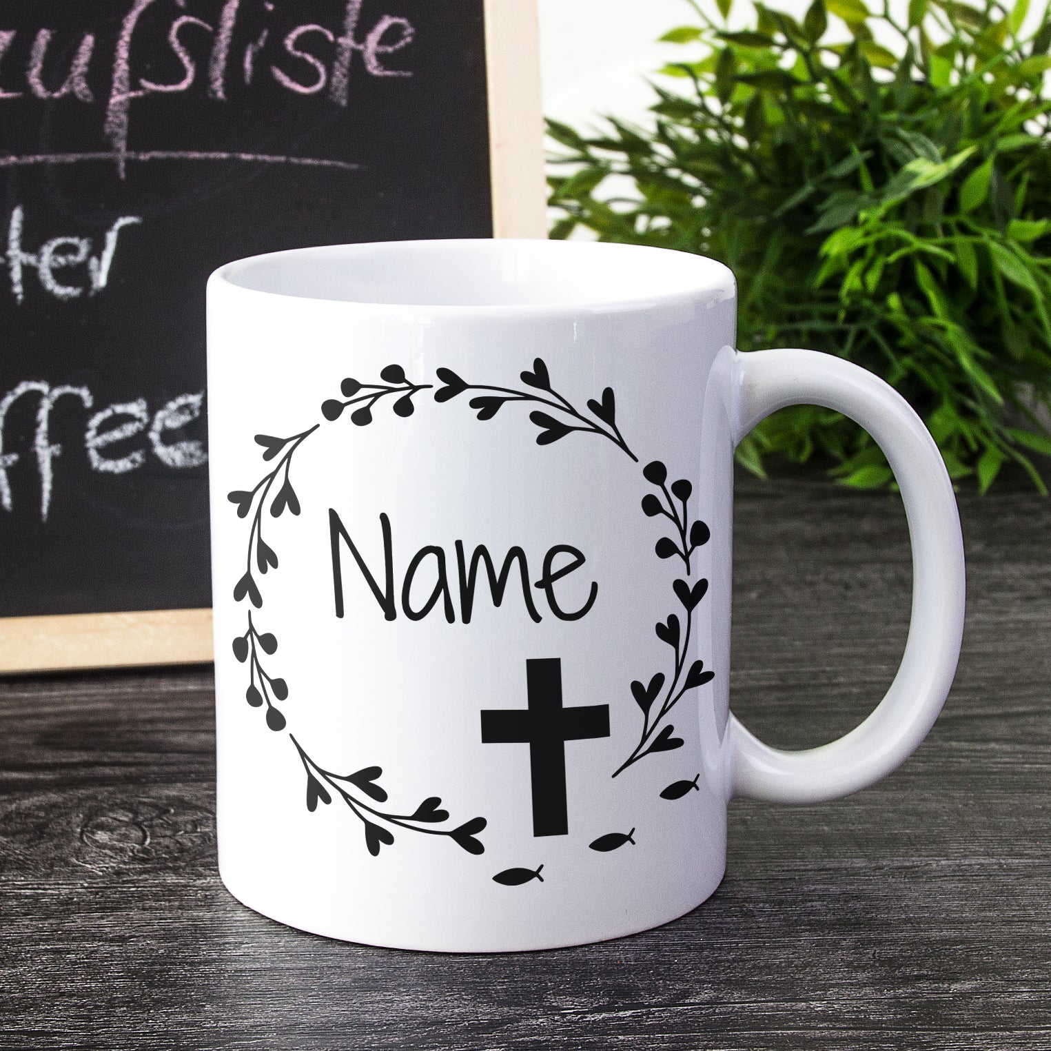 Weißer Becher mit schwarzem Kreuz und Namen.