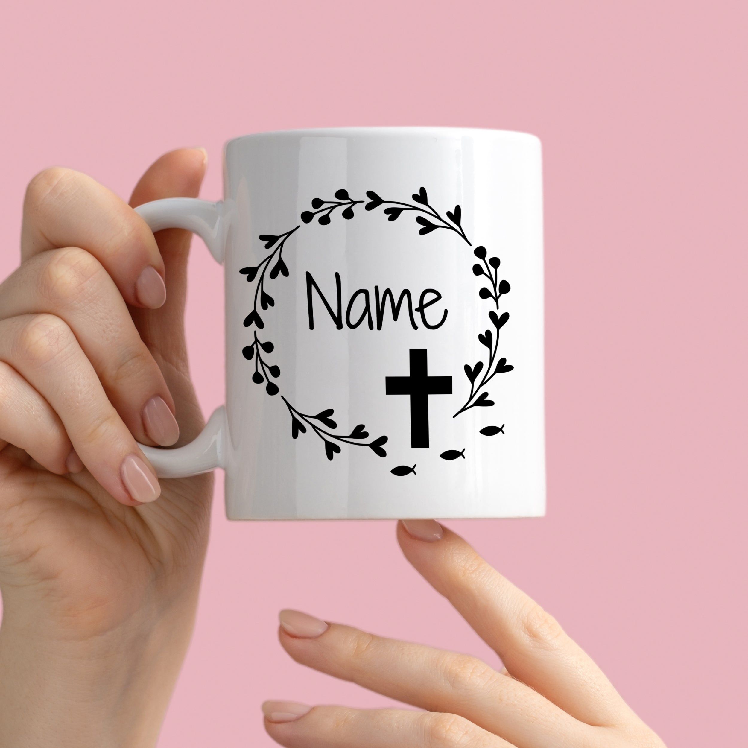 Weiße Tasse mit personalisiertem Namen und Kreuz-Design.