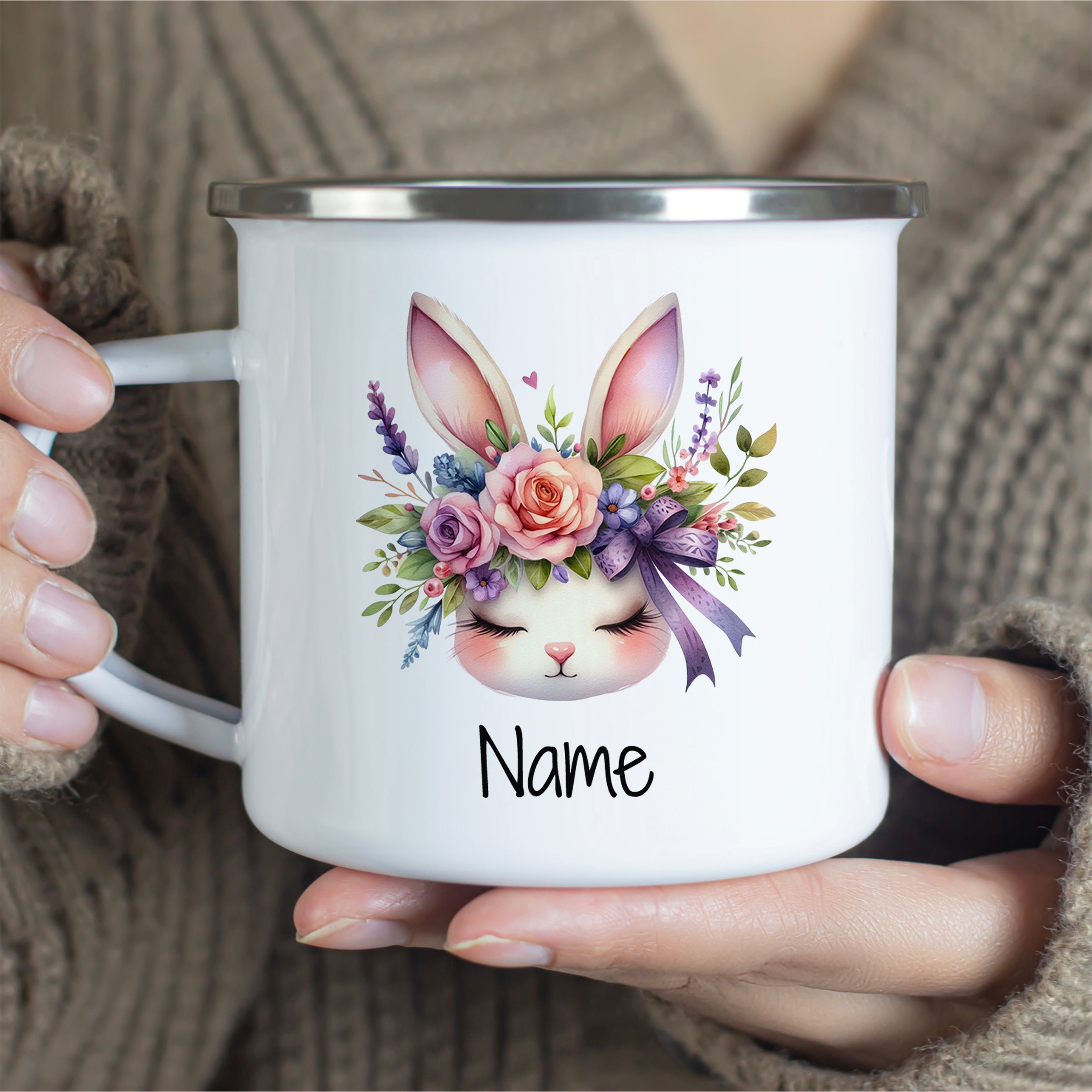 Weißer Emaille-Becher mit buntem Hasenmotiv und Namen.
