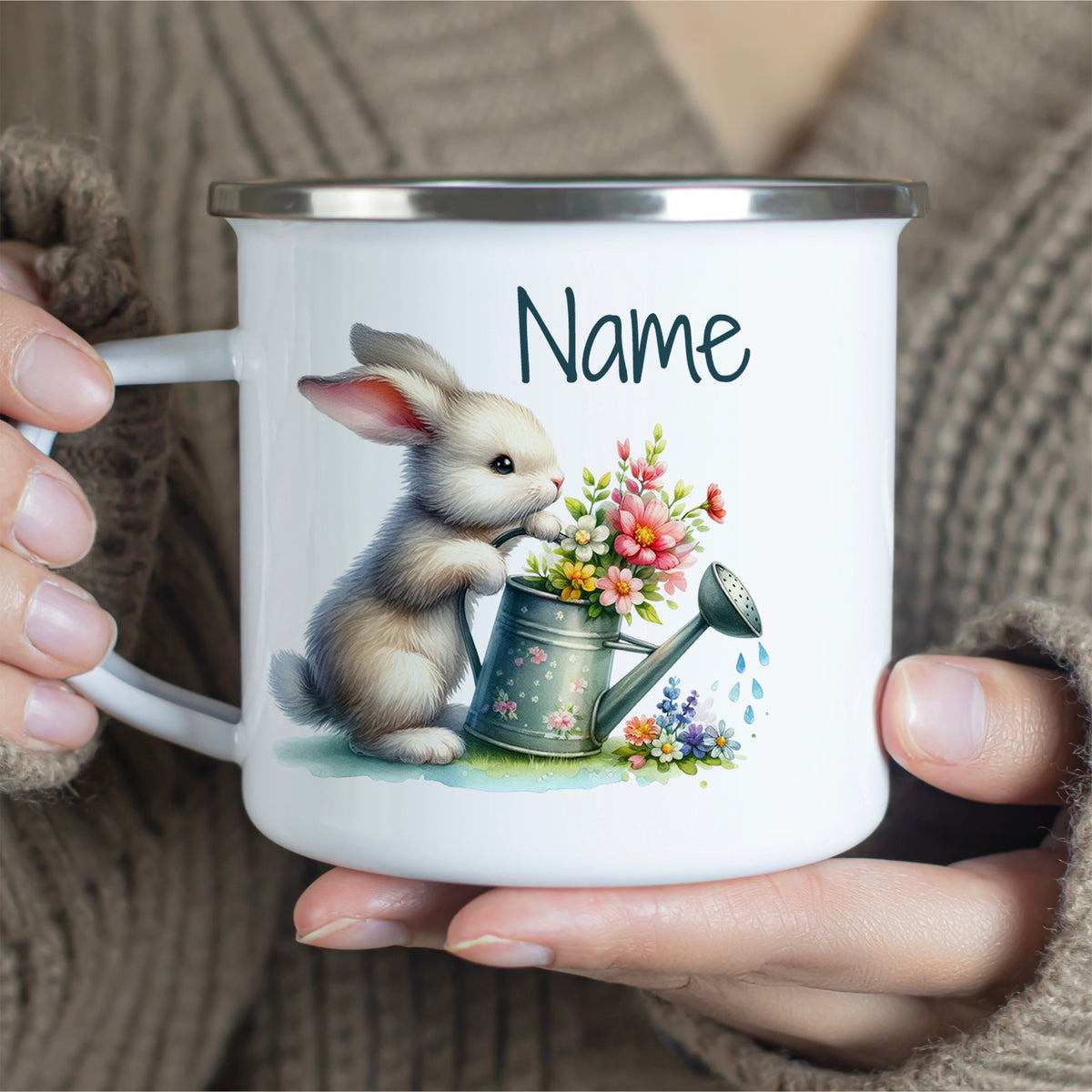 Weißer Emaillebecher mit Hase und Blumenmotiv.