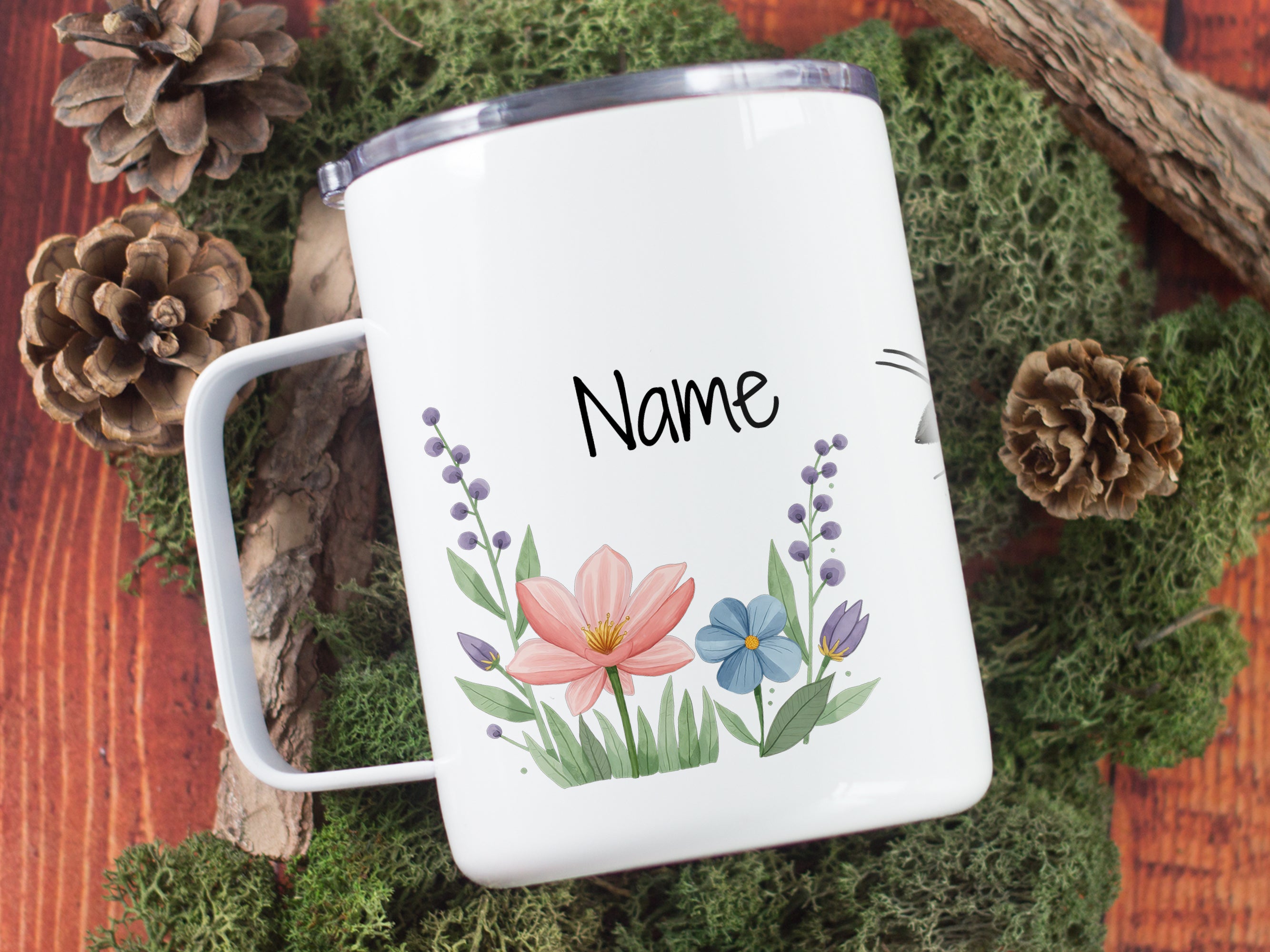 Weißer Becher mit bunten Blumen und personalisierbarem Namen.
