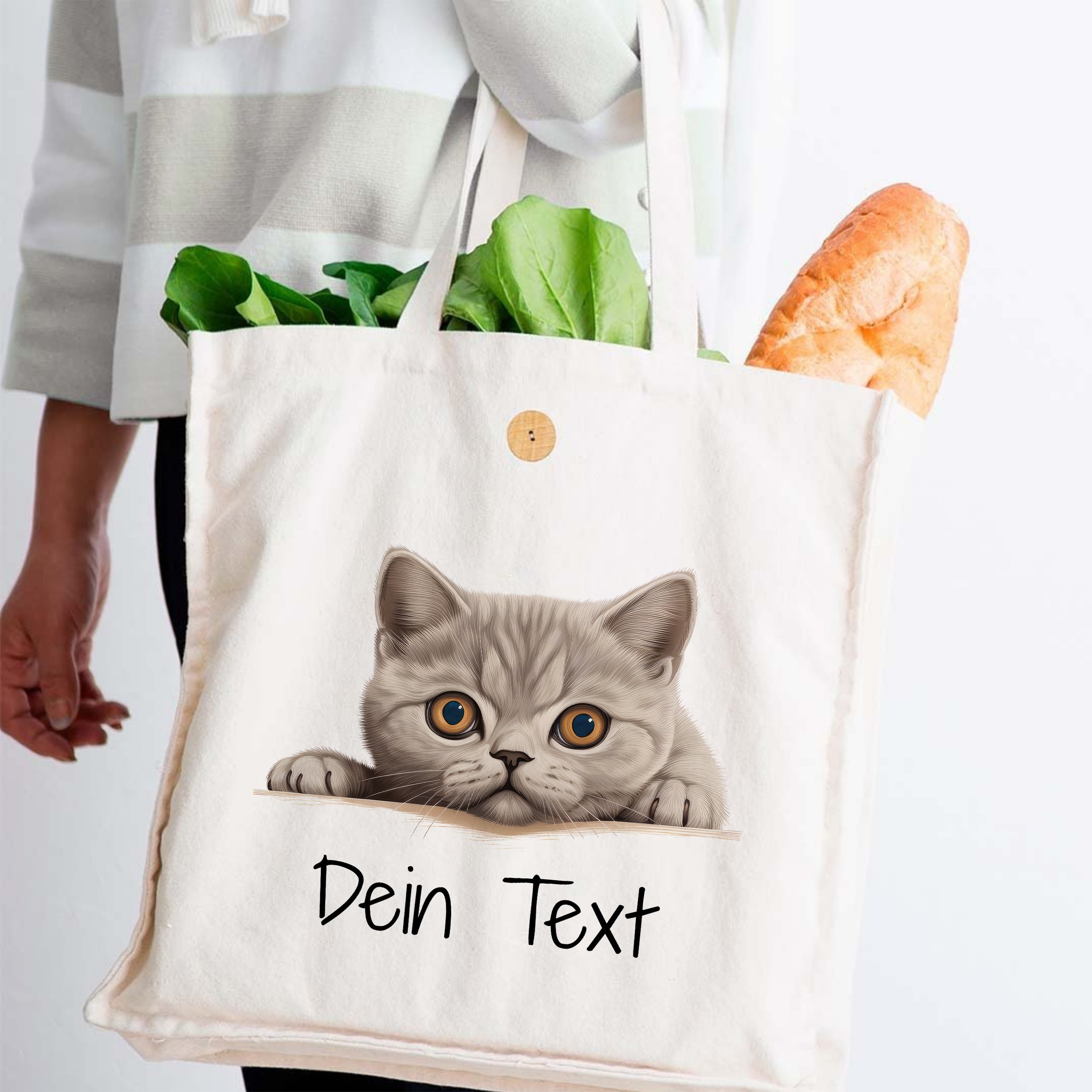 Beige Stofftasche mit Katzenmotiv und frischem Gemüse.
