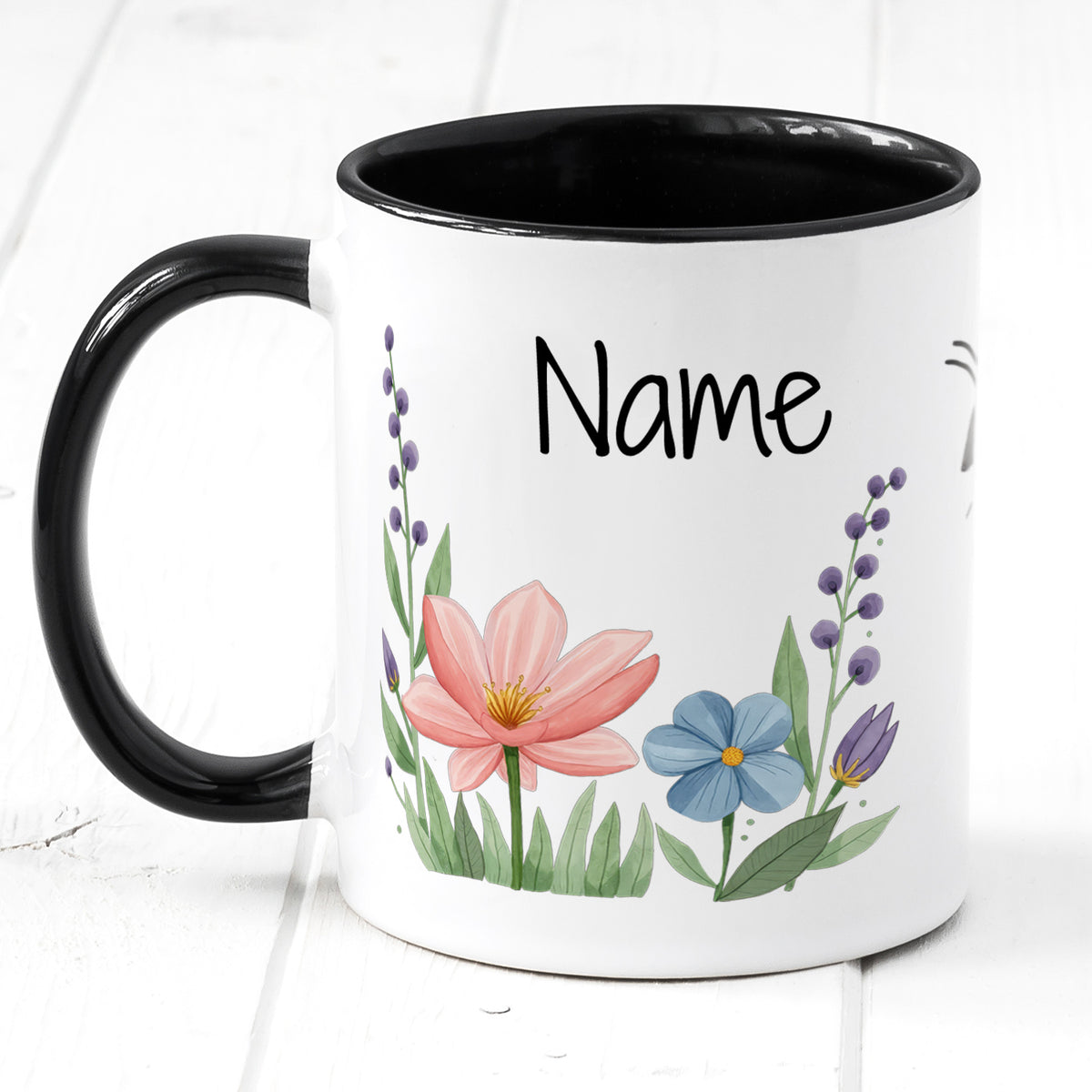 Tasse mit bunten Blumen und schwarzem Henkel.