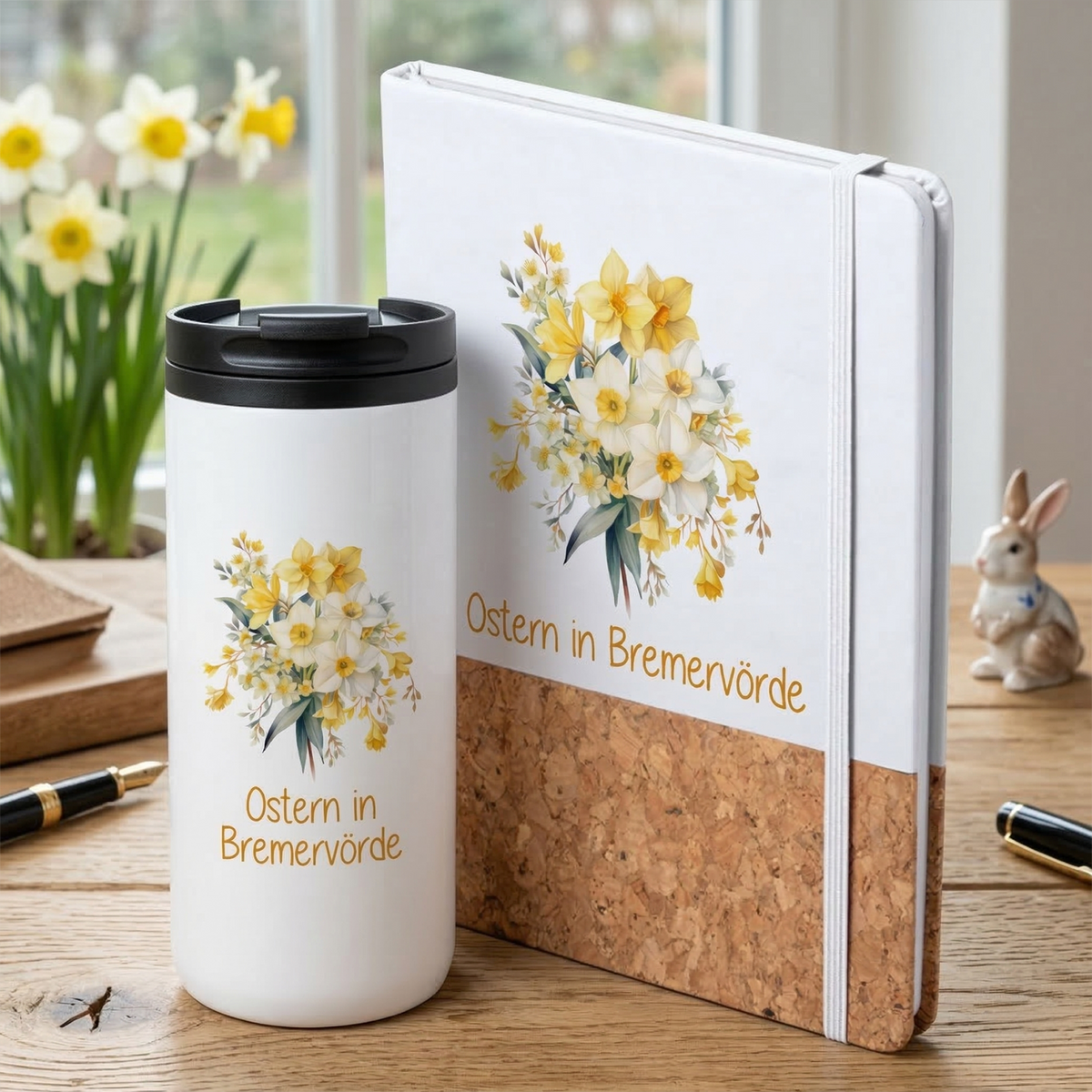 Weißer Becher mit gelben Blumen und Notizbuch.