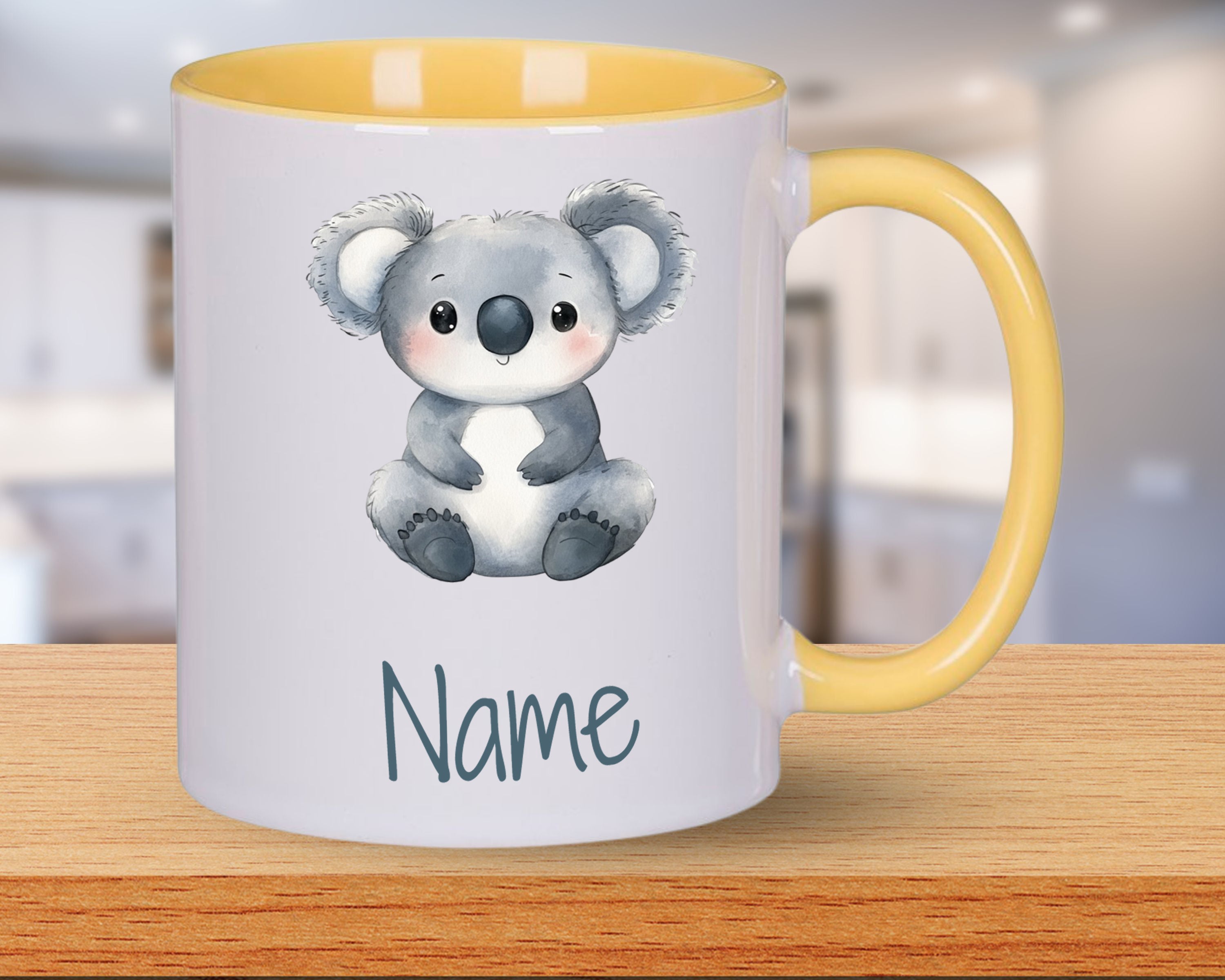 Tasse mit Koala-Motiv und gelbem Henkel.