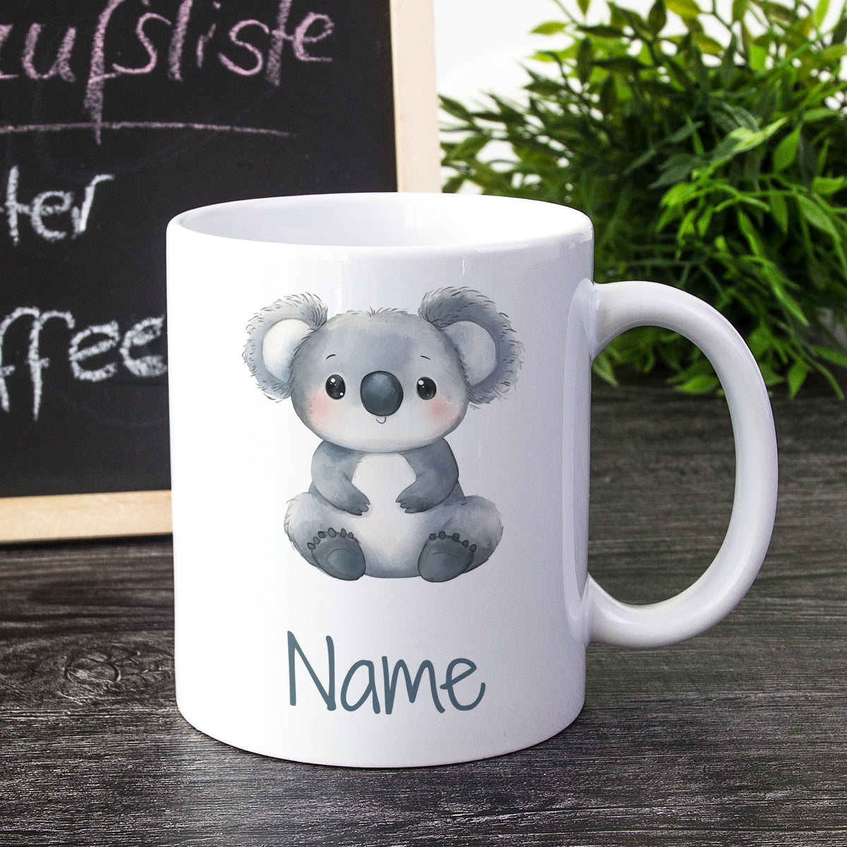 Weißer Kaffeebecher mit koalaähnlichem Design und Platz für Namen.