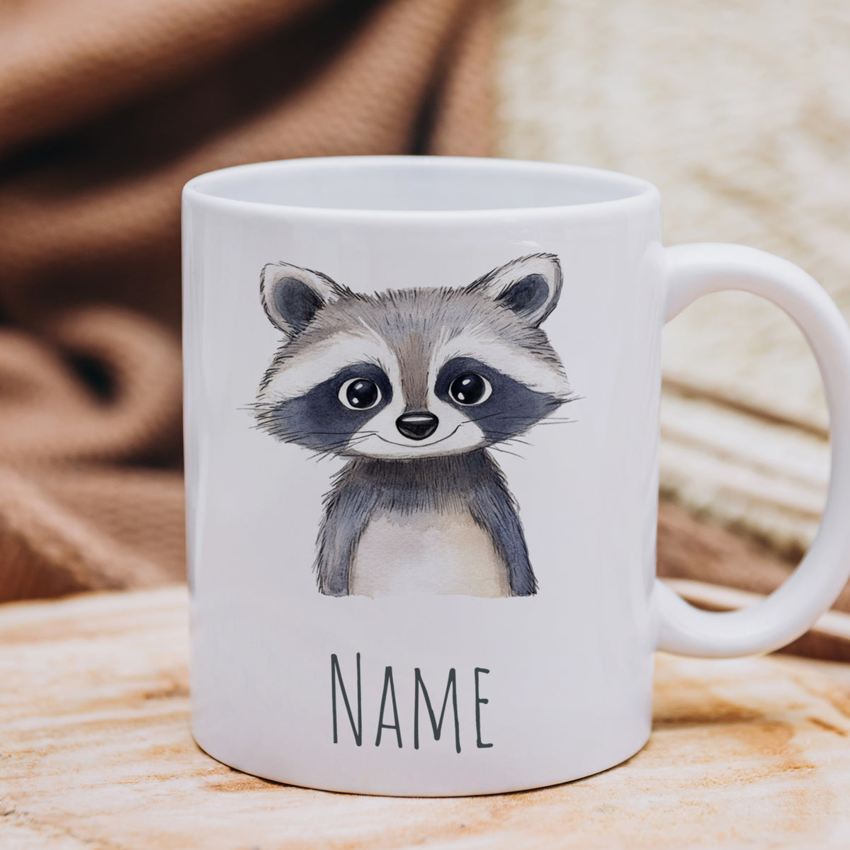 Weißer Becher mit niedlichem Waschbären-Motiv und Platz für Namen.