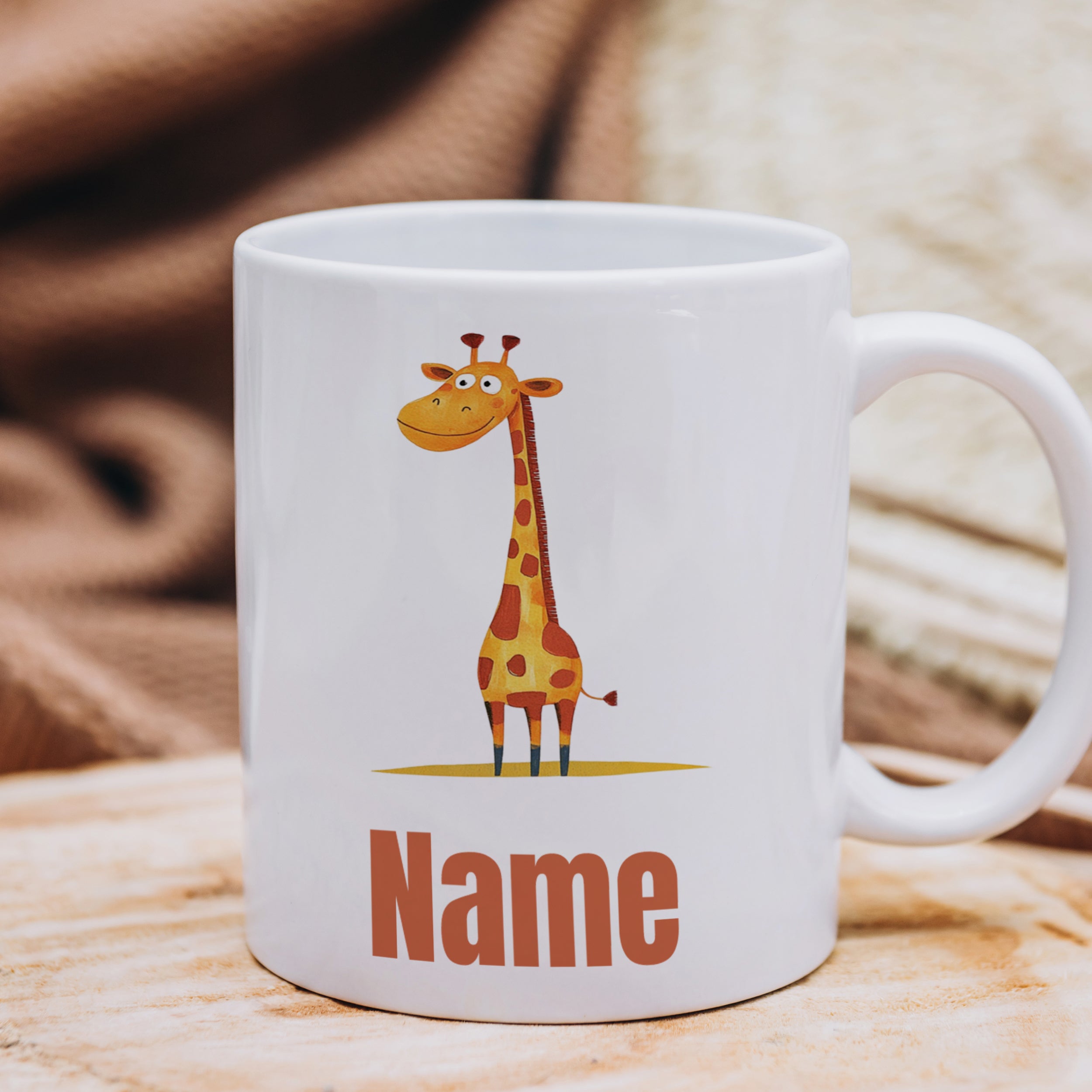 Weiße Tasse mit Giraffenmotiv und Namensschriftzug.