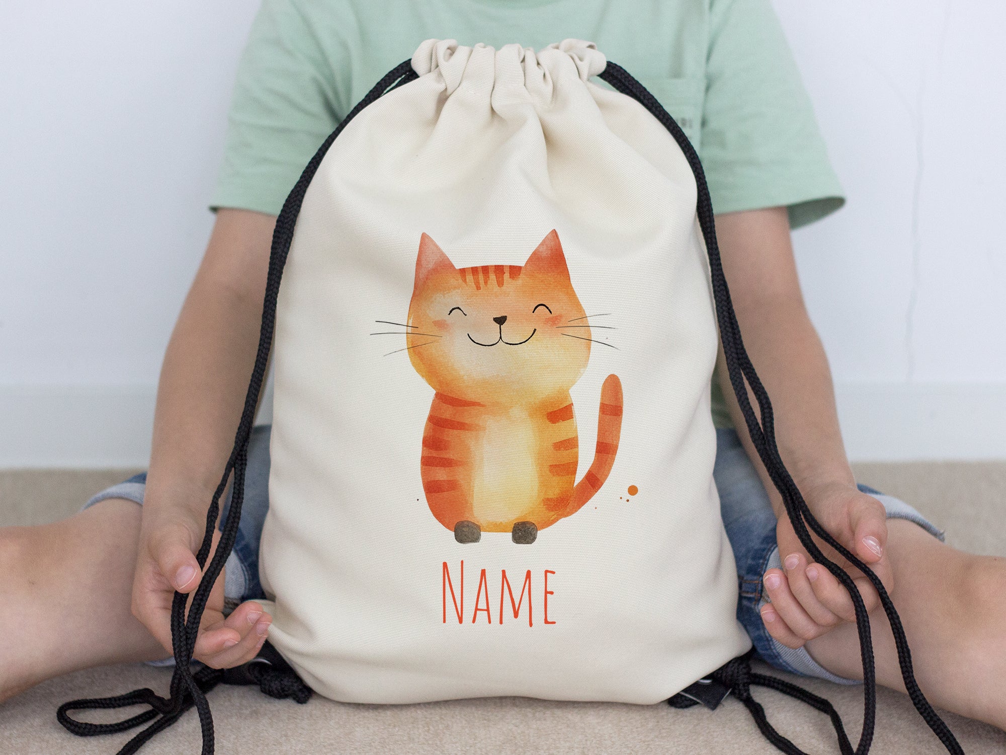 Beiger Turnbeutel mit niedlicher Katze und personalisierbarem Namen.