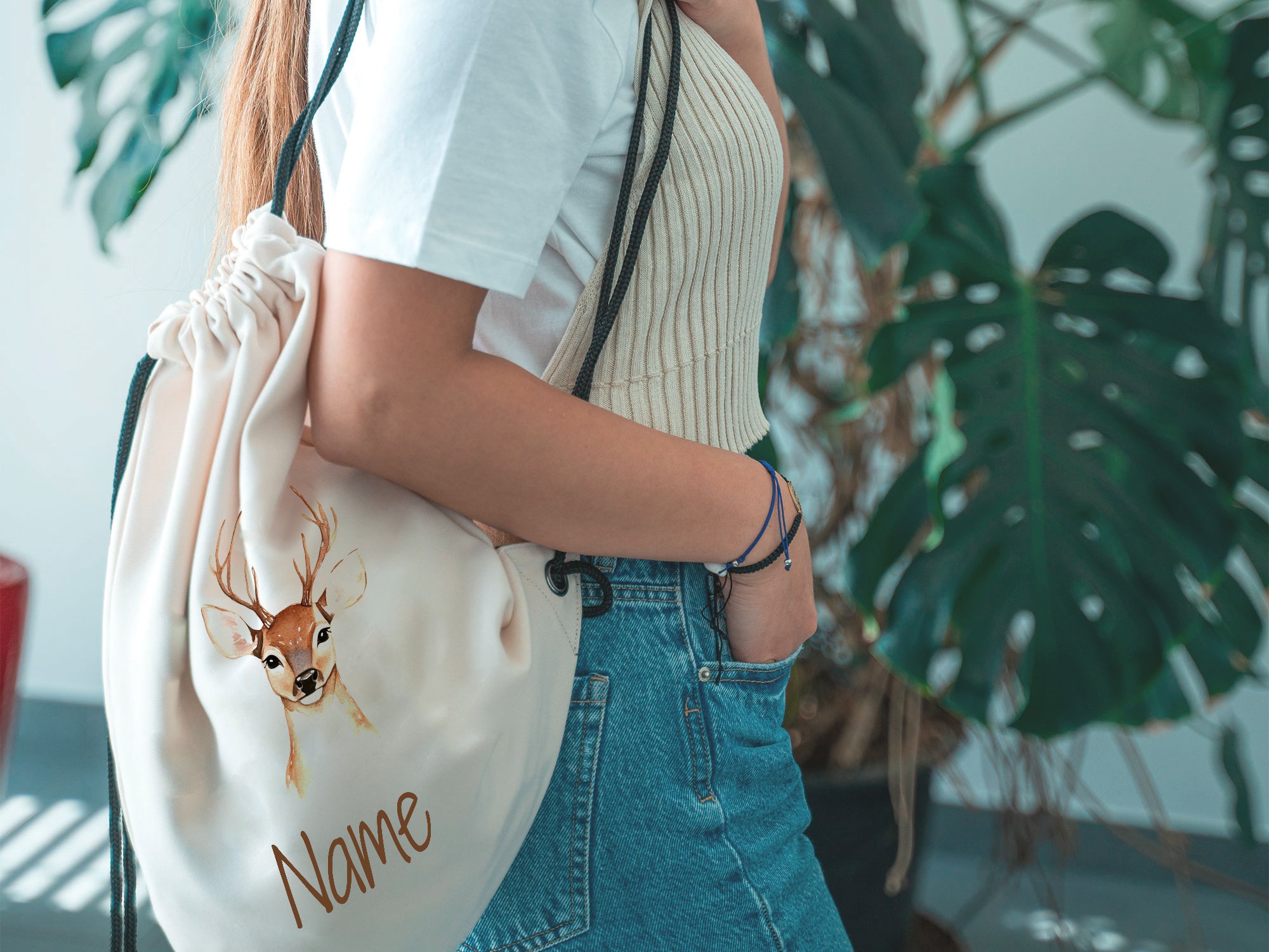 Beige Rucksack mit Hirschmotiv und personalisiertem Namen.