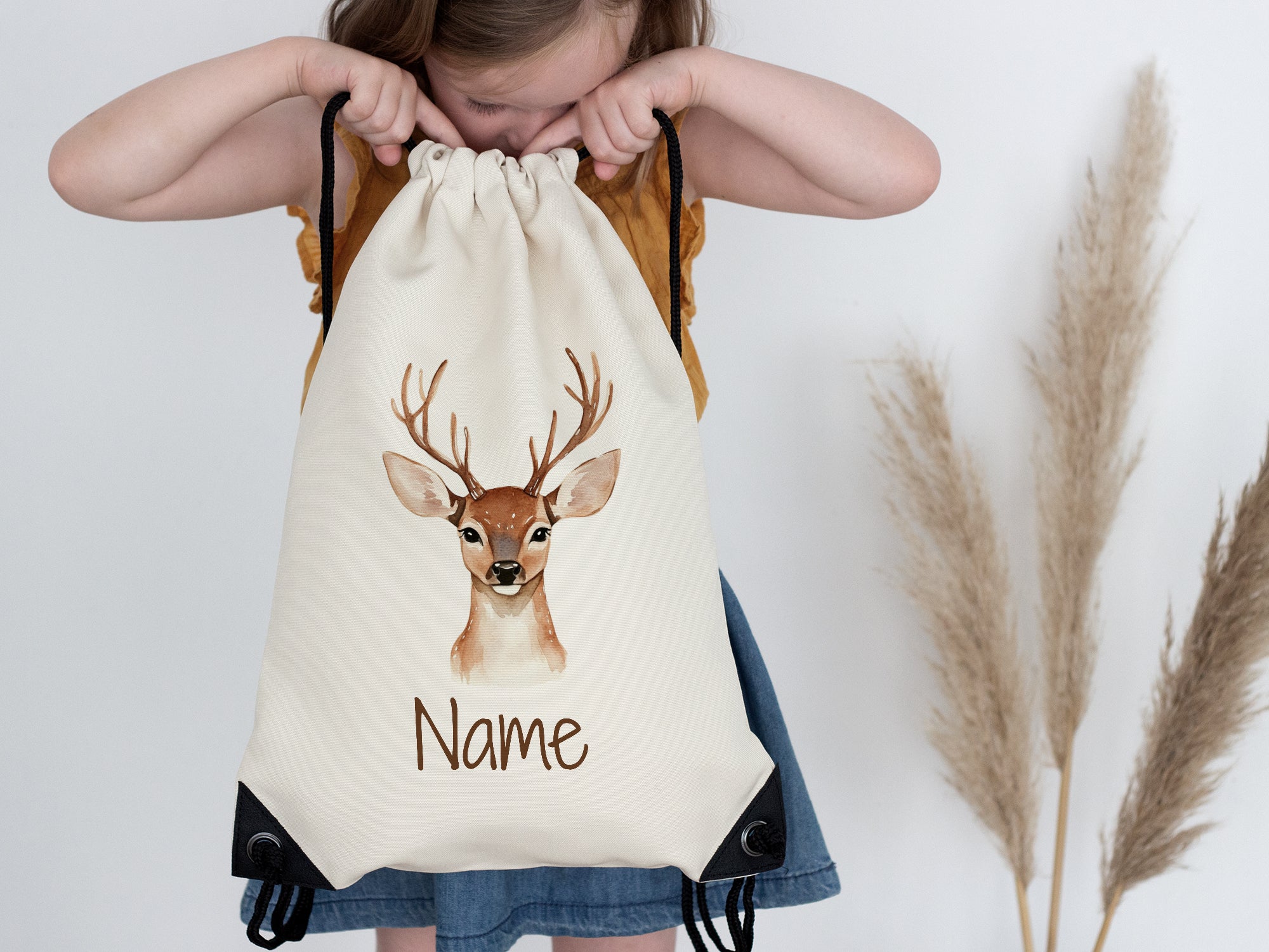 Beige Rucksack mit Reh-Motiv und personalisierbarem Namen.