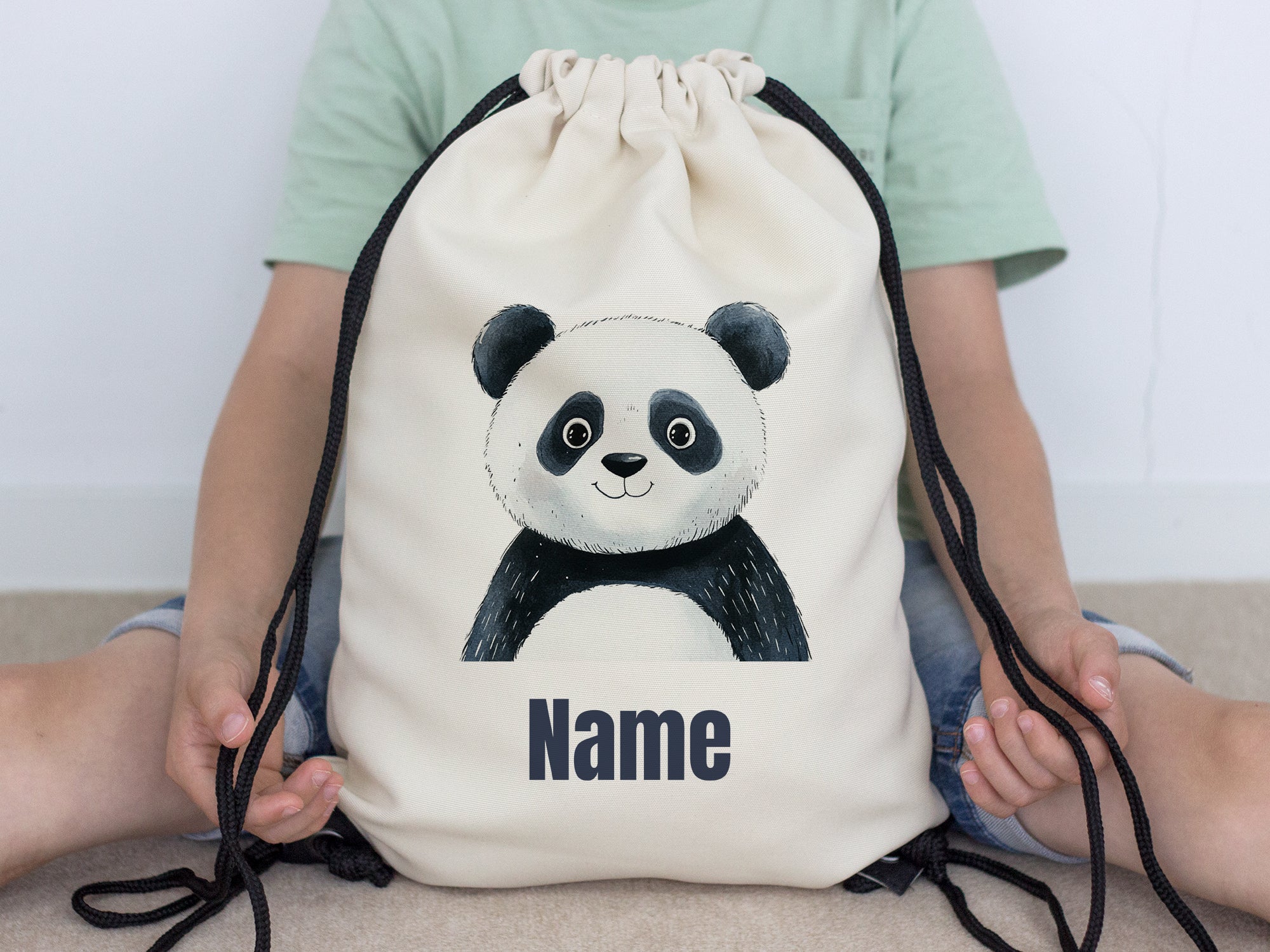 Beige Turnbeutel mit Panda-Motiv und personalisierbarem Namen.