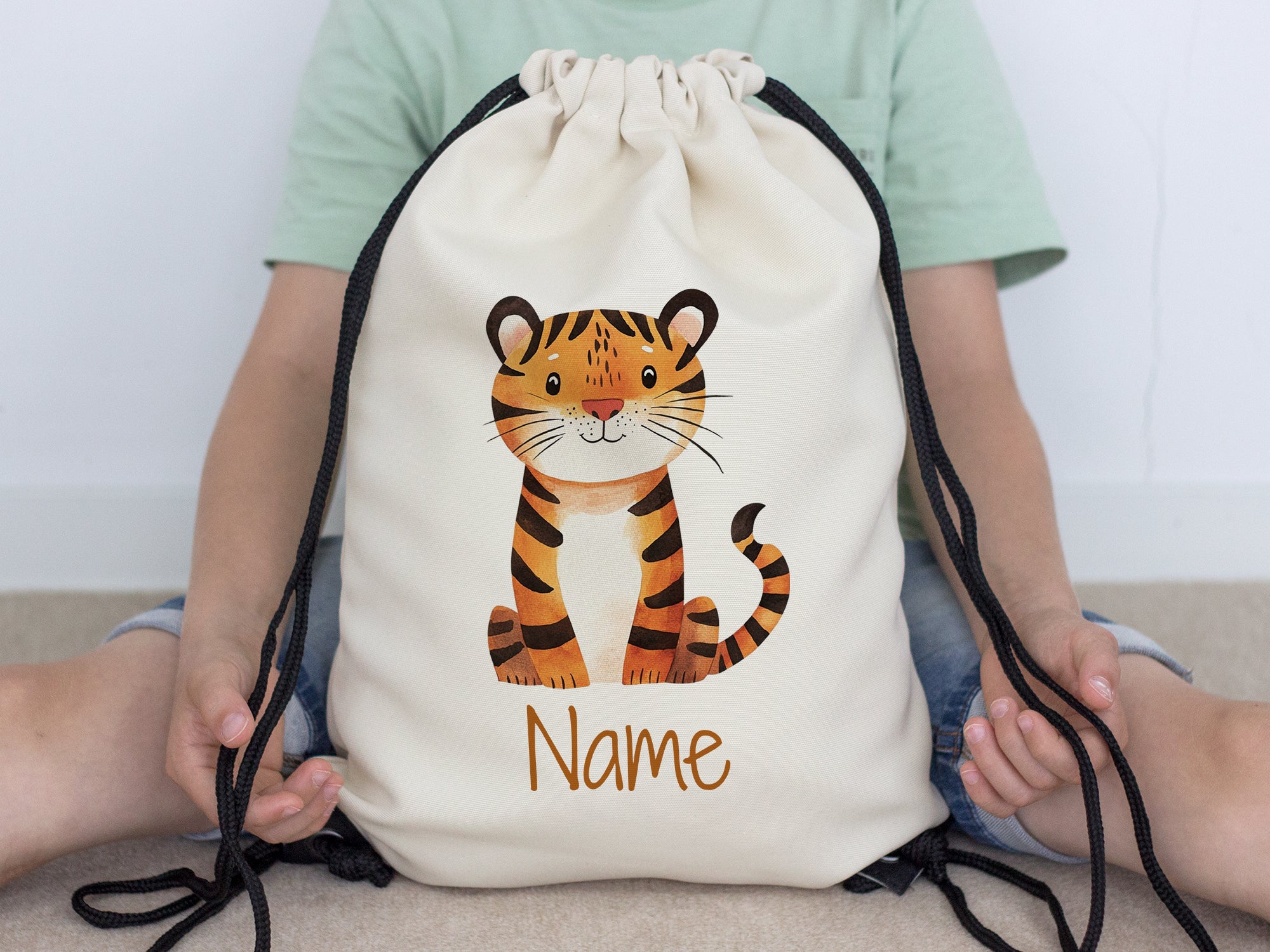 Beige Turnbeutel mit Tiger-Motiv und personalisiertem Namen.