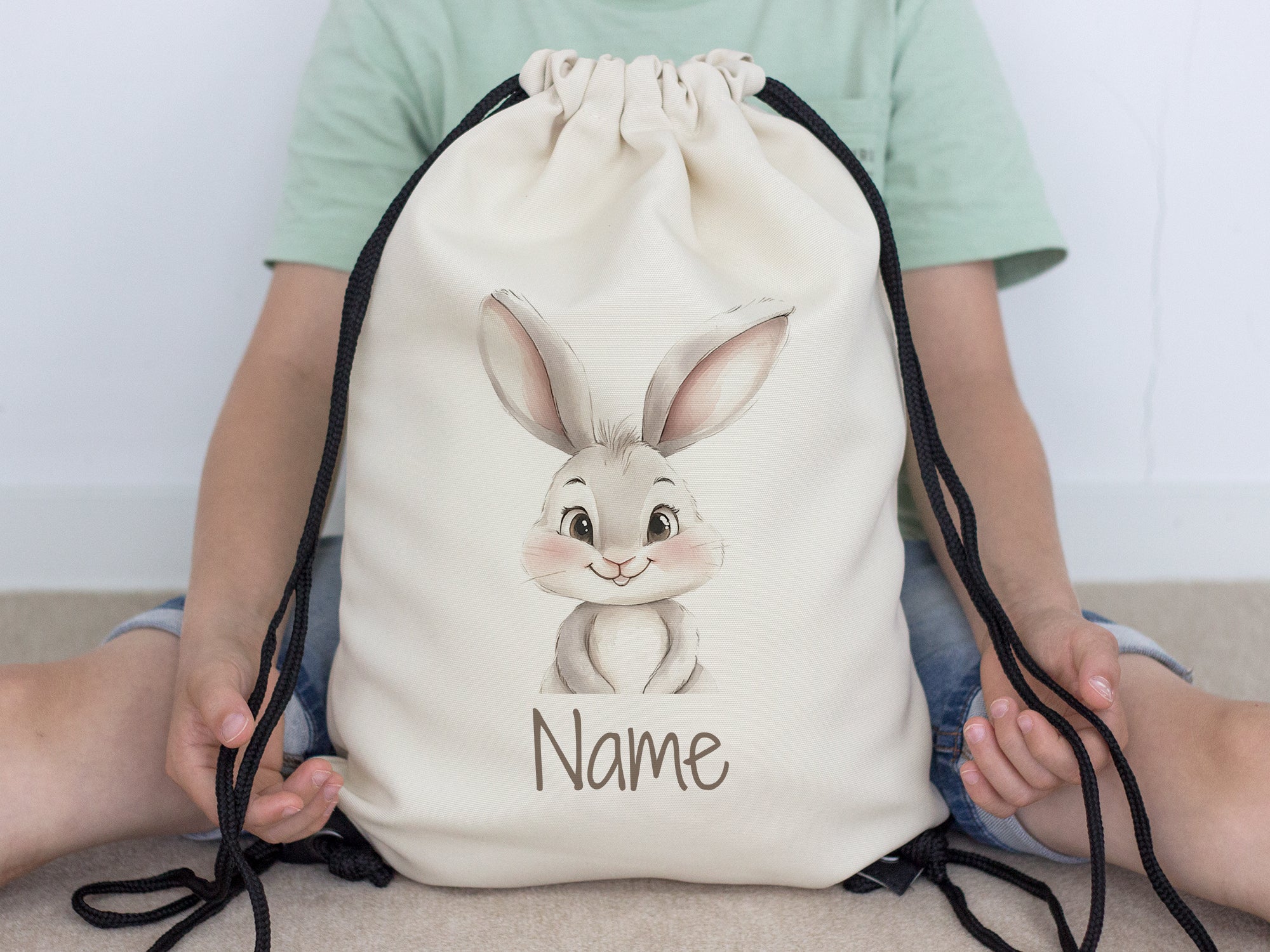 Beige Rucksack mit niedlichem Hasenmotiv und personalisierbarem Namen.