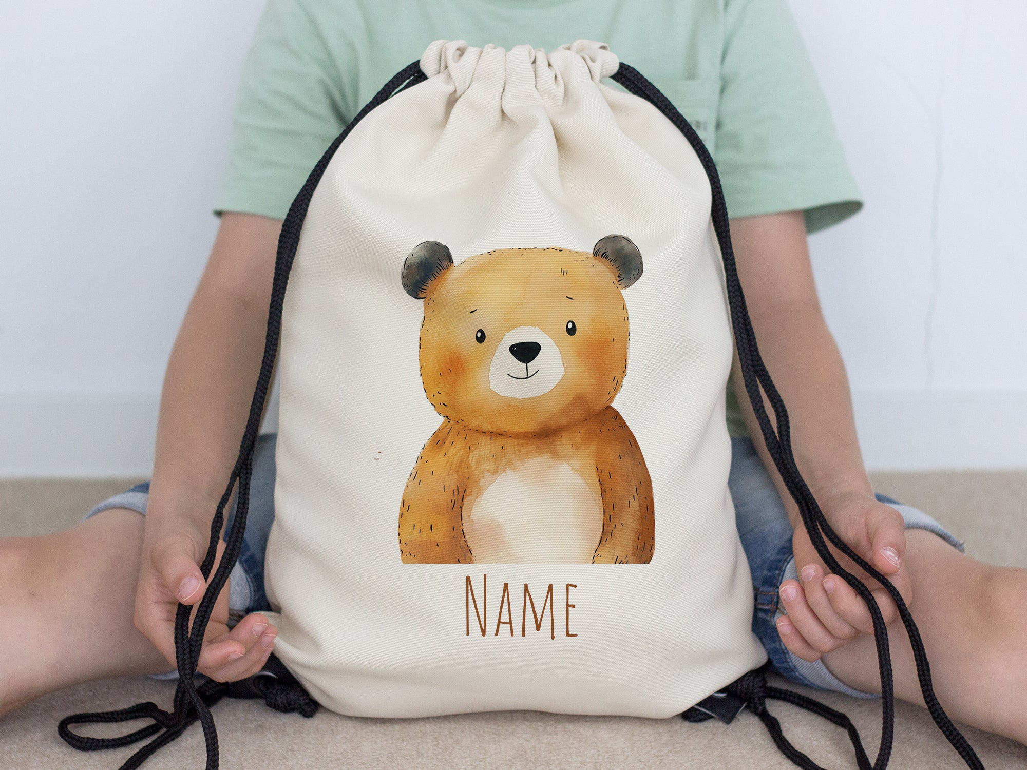 Beige Rucksack mit Bärenmotiv und personalisierbarem Namen.