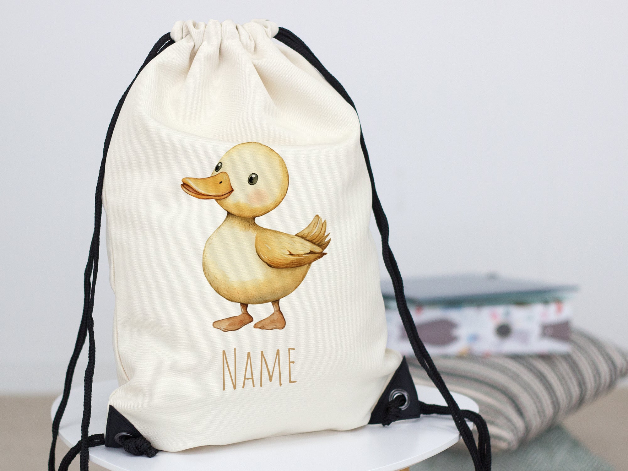 Beiger Rucksack mit Entenmotiv und Platz für Namen.