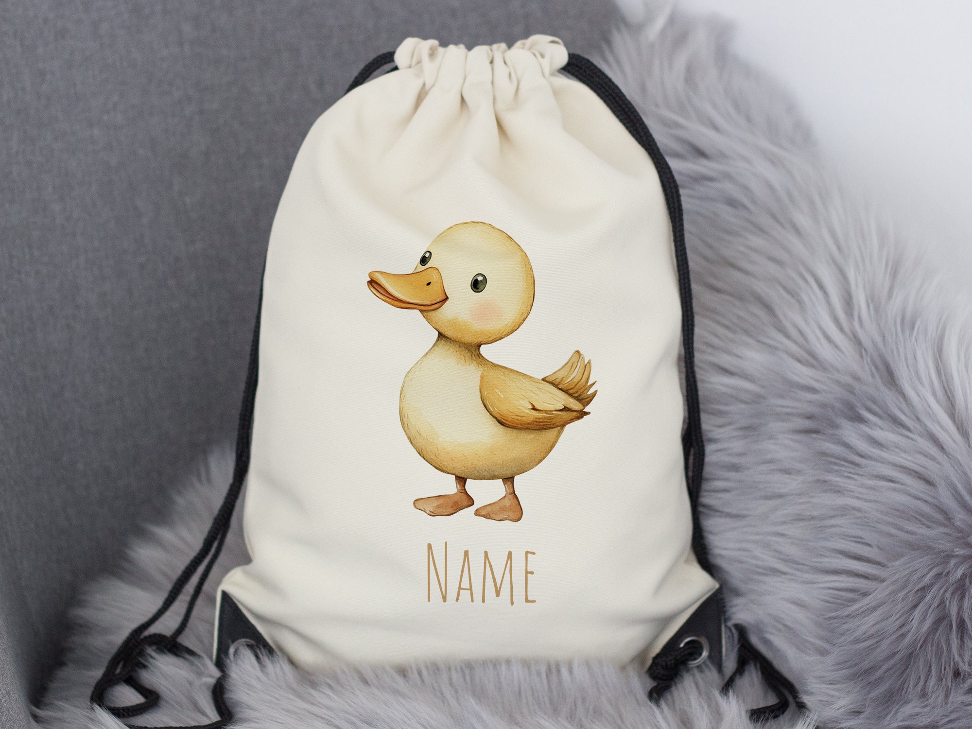 Beige Rucksack mit Entenmotiv und personalisierbarem Namen.
