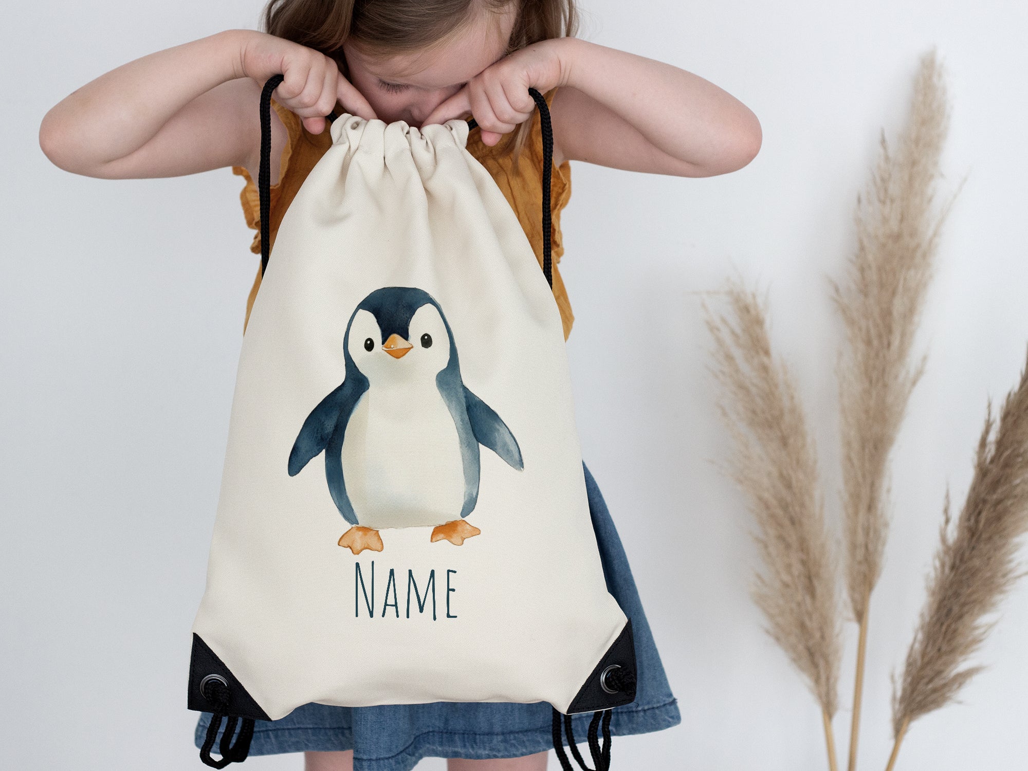 Beige Turnbeutel mit Pinguin-Motiv und personalisierbarem Namen.