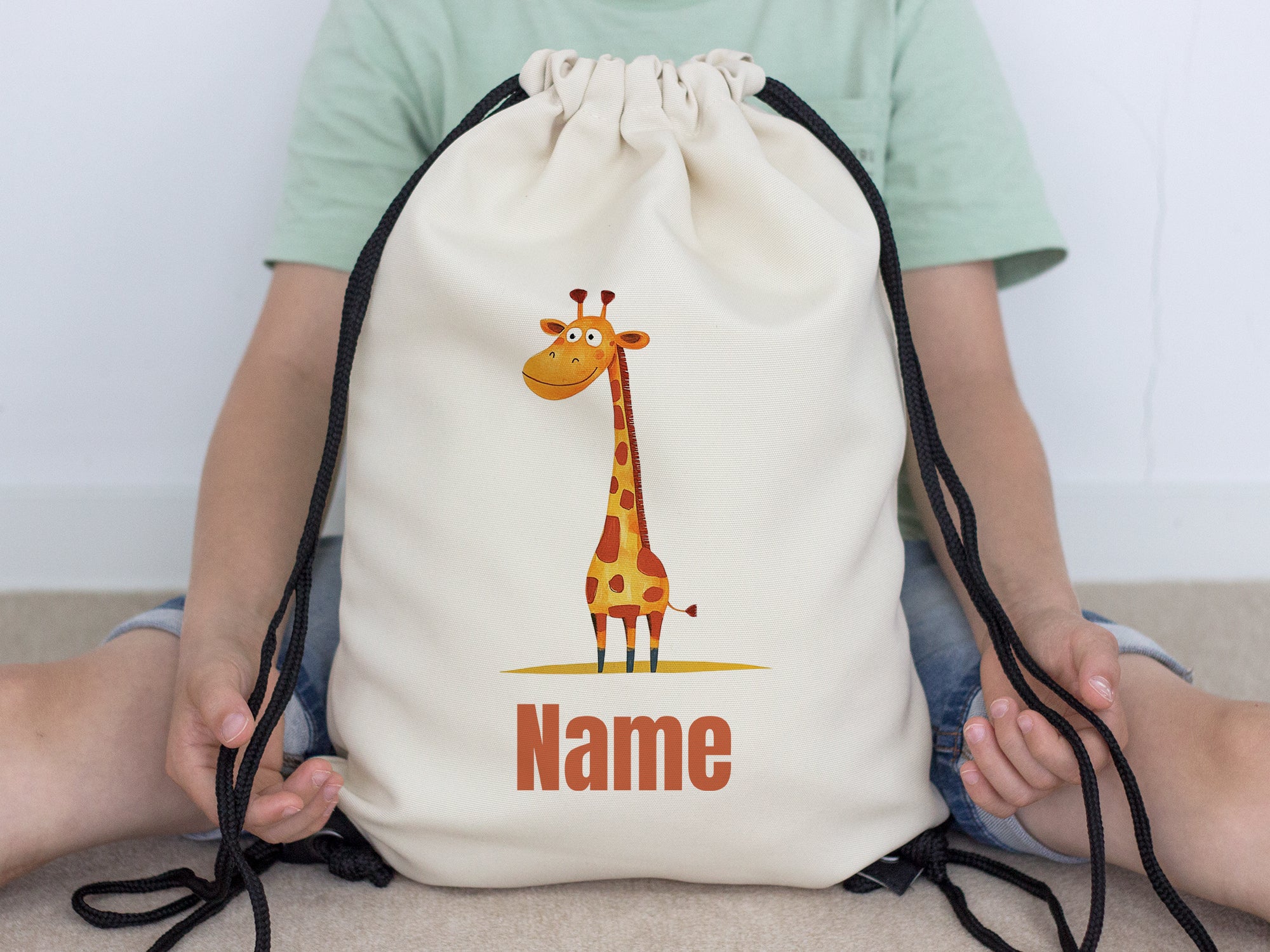 Beige Turnbeutel mit Giraffenmotiv und Platz für Namen.