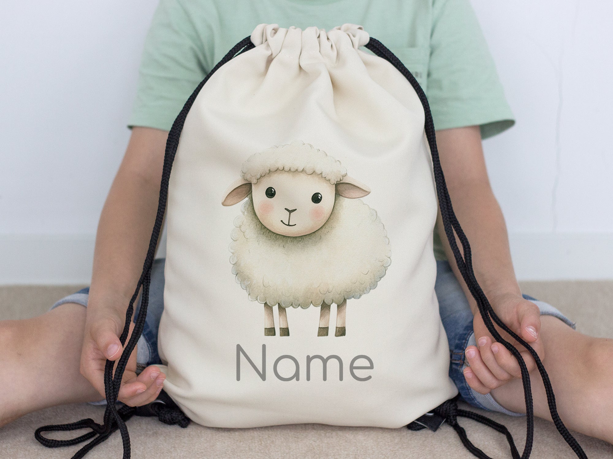 Beige Rucksack mit Schafmotiv und Platz für Namen.