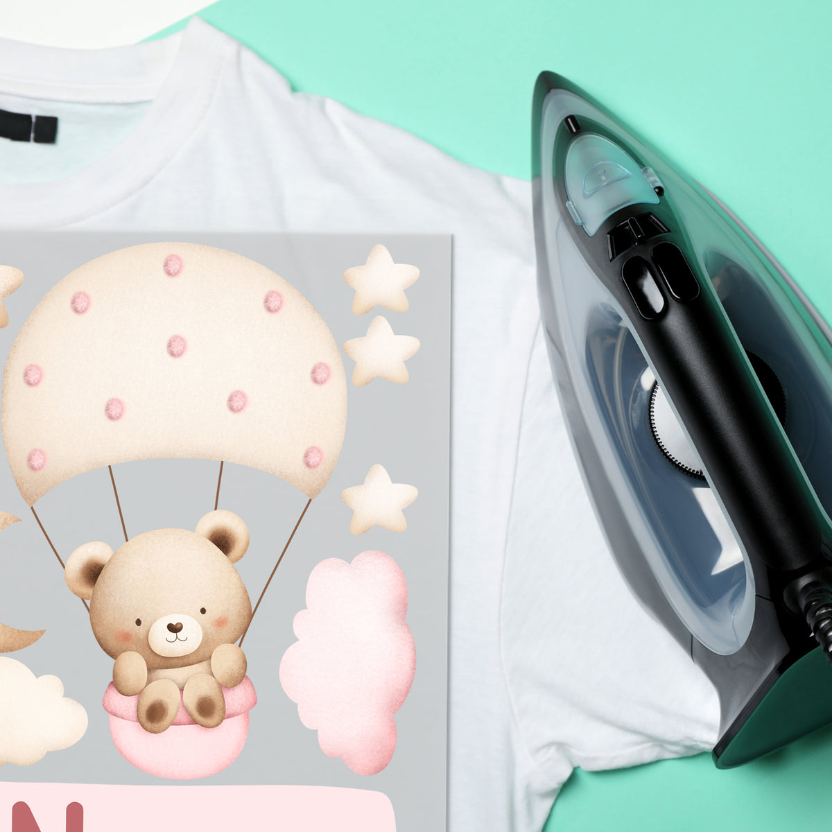Weißes T-Shirt mit niedlichem Bärenmotiv und Dampfbügeleisen.