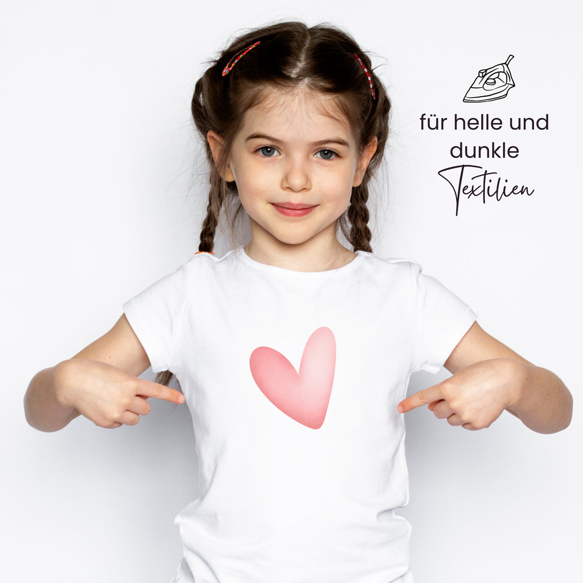 Weißes T-Shirt mit pinkem Herzmotiv.