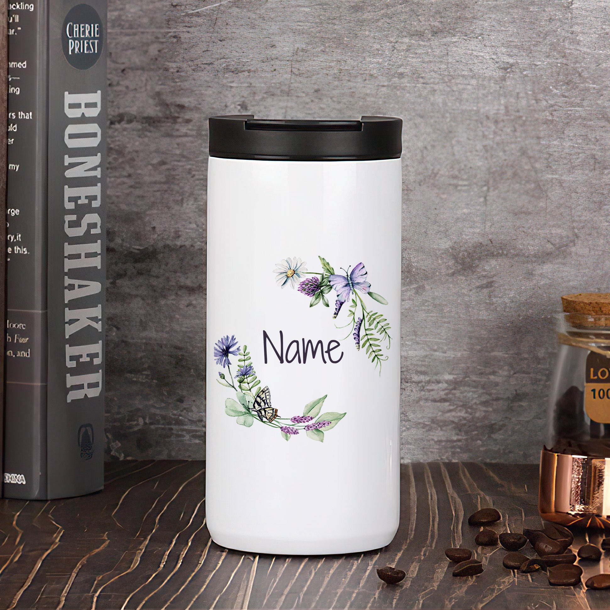 Weißer Thermobecher mit floralen Motiven und personalisierbarem Namen.