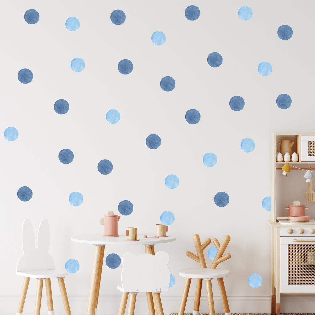 Blaue und hellblaue Punkte auf weißer Wand.