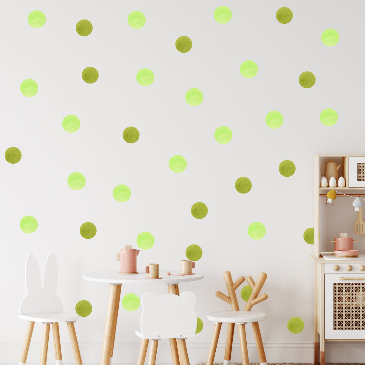 Grüne Punkte auf weißer Wand mit Kindermöbeln.