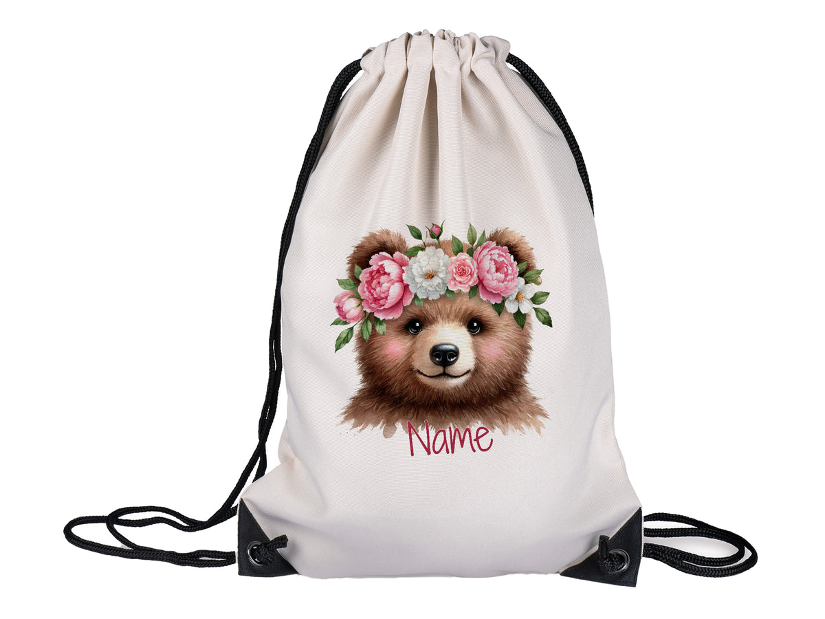 Beige Turnbeutel mit Bärenmotiv und Blumenkranz.