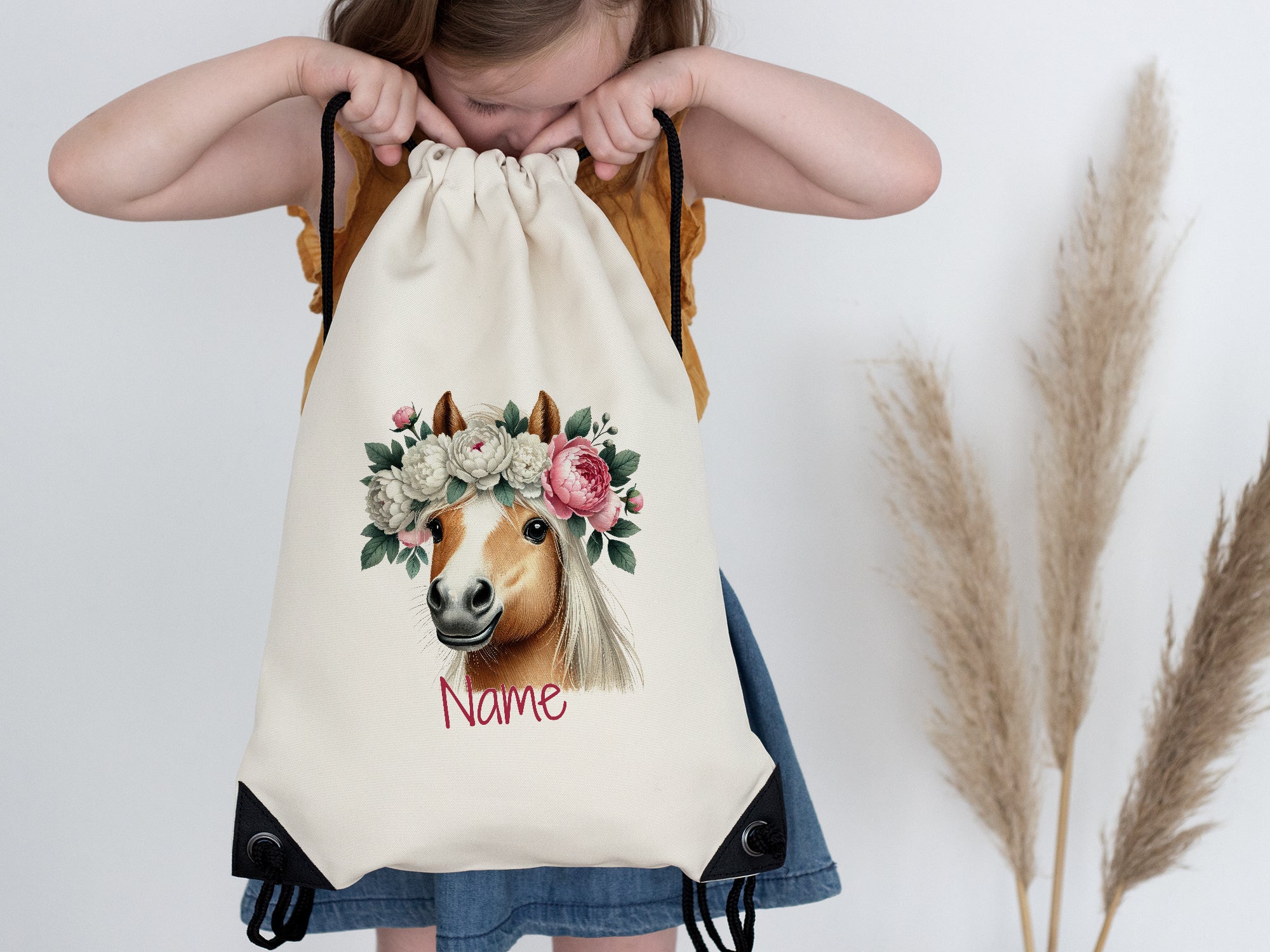 Beige Turnbeutel mit Pferdemotiv und Blumenkranz.