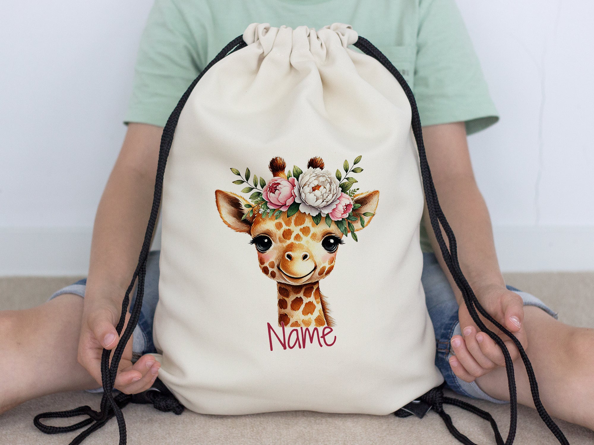 Beige Rucksack mit Giraffenmotiv und Blumenkranz.