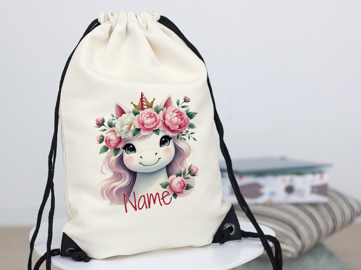 Beige Turnbeutel mit Einhorn und Blumenmotiv.