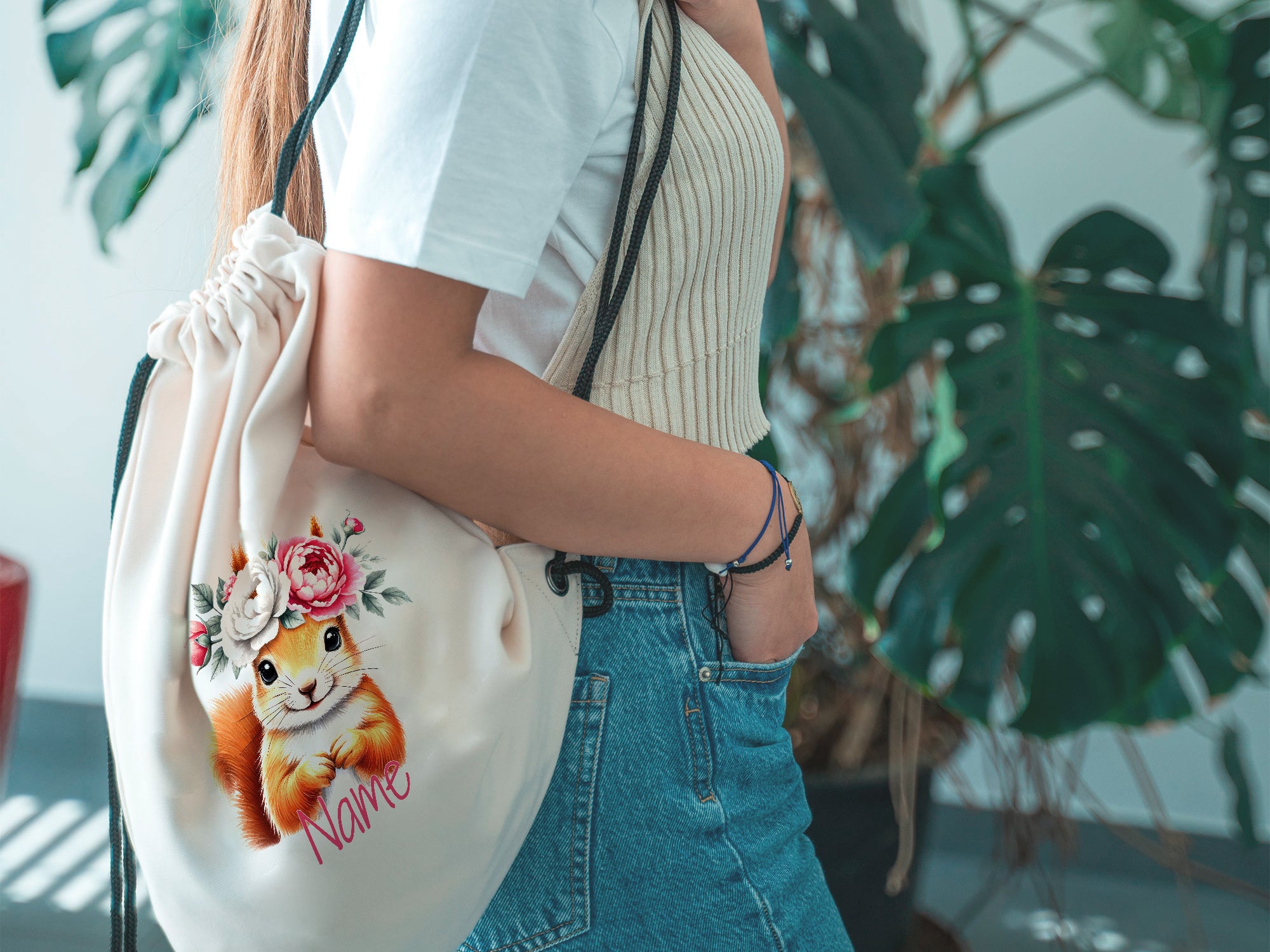 Beige Turnbeutel mit Tiermotiv und Blumenverzierung.