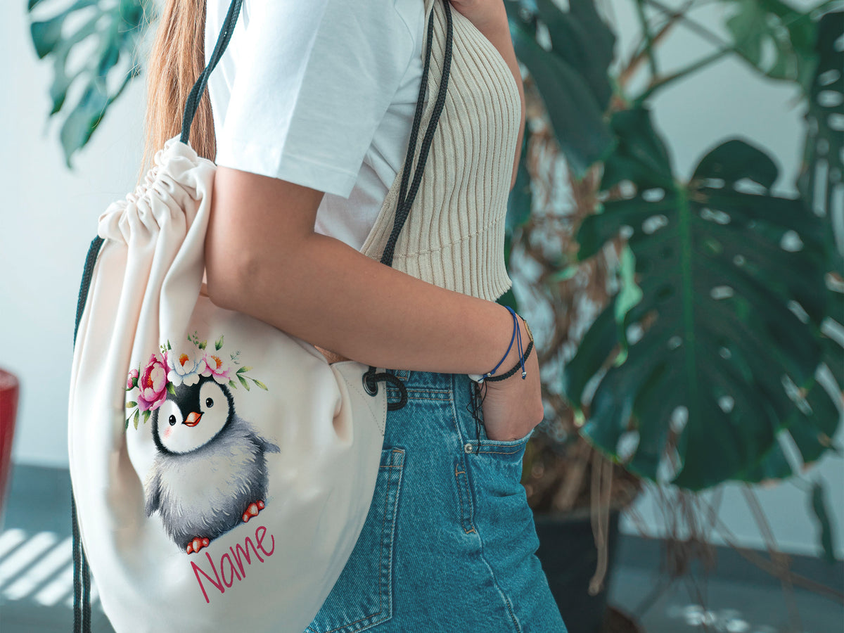 Beige Turnbeutel mit Pinguin-Motiv und personalisiertem Namen.