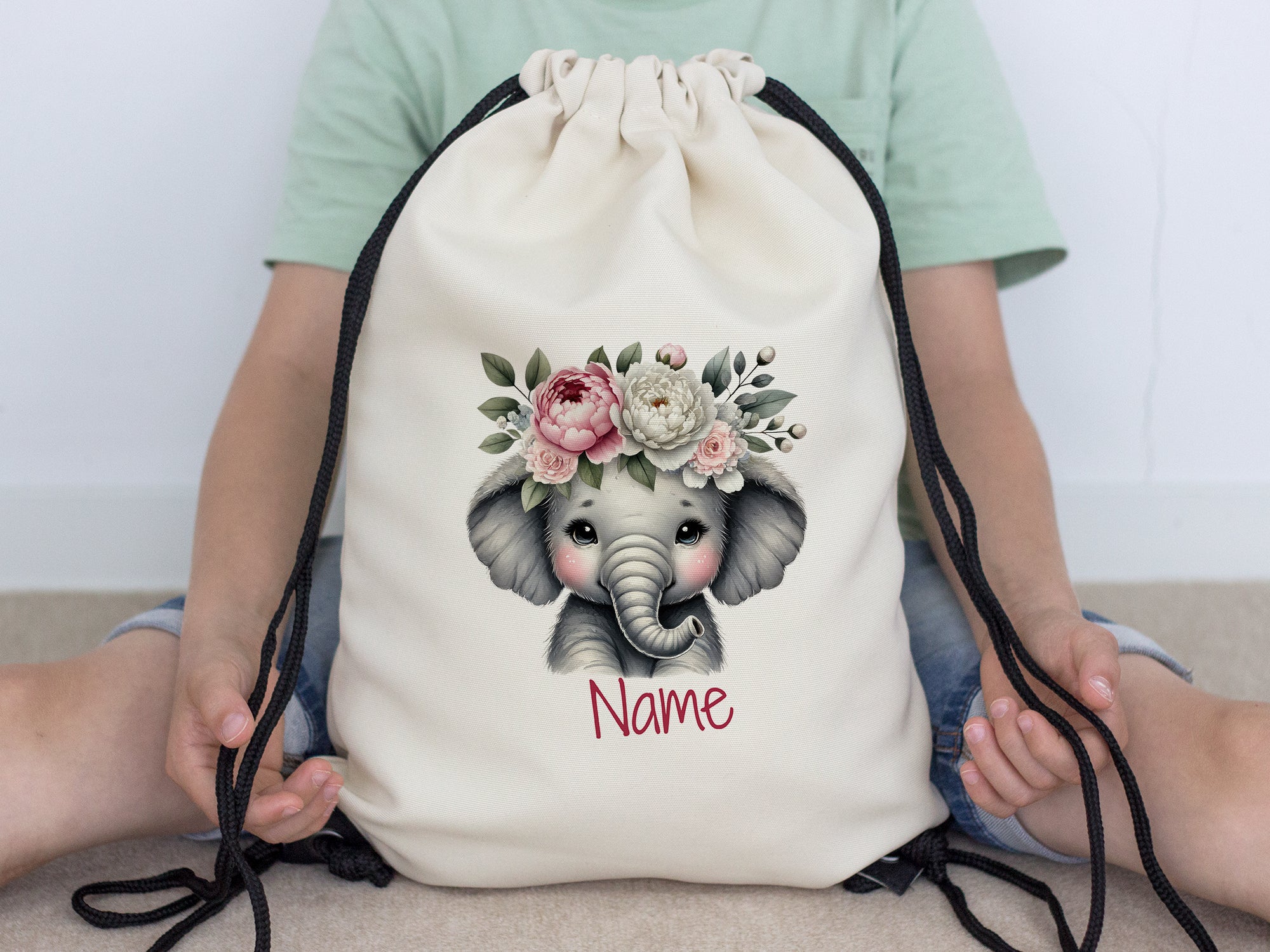 Beige Rucksack mit Elefantenmotiv und Blumenkranz.