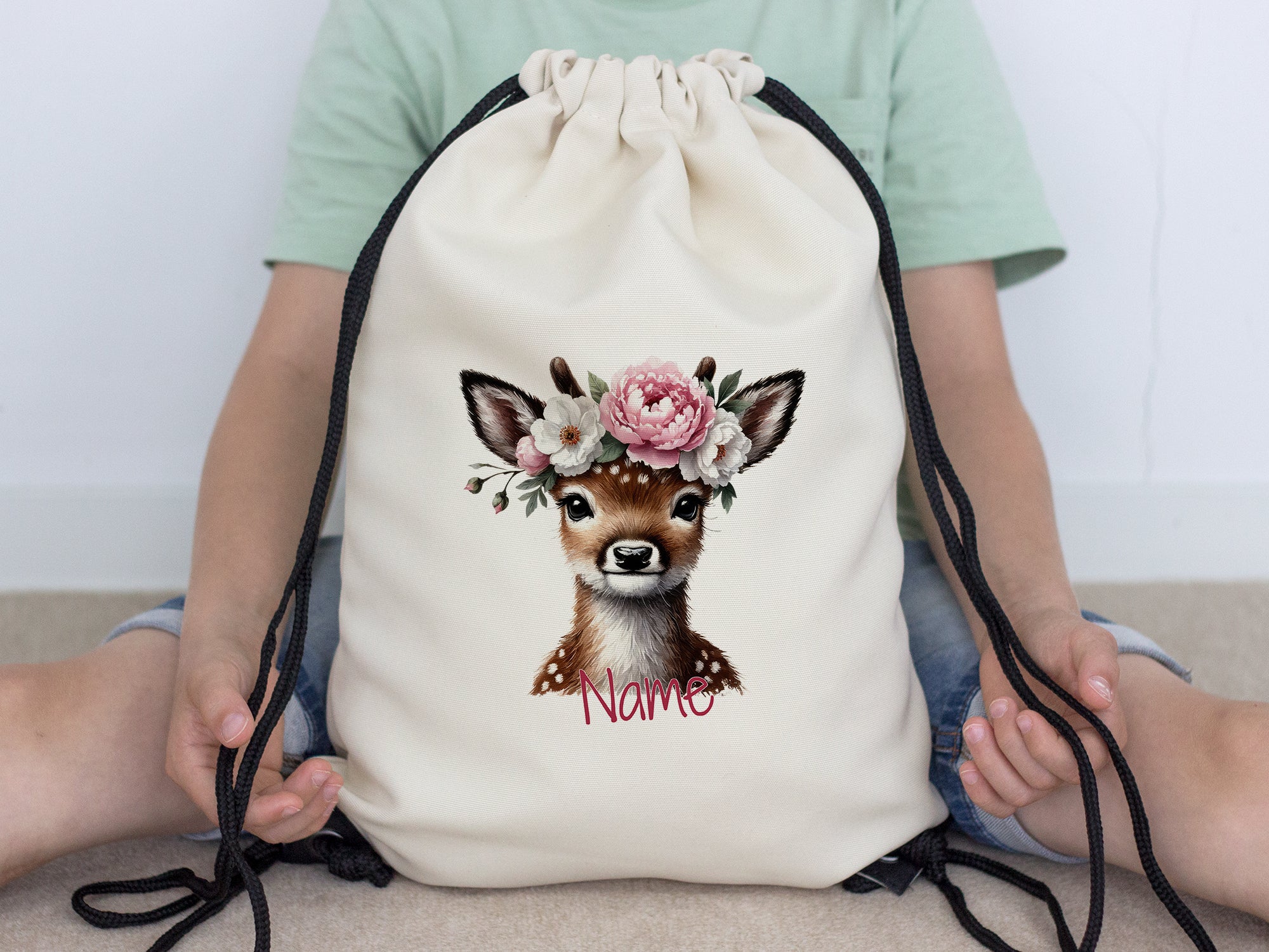 Beige Rucksack mit Reh-Motiv und Blumenkranz.