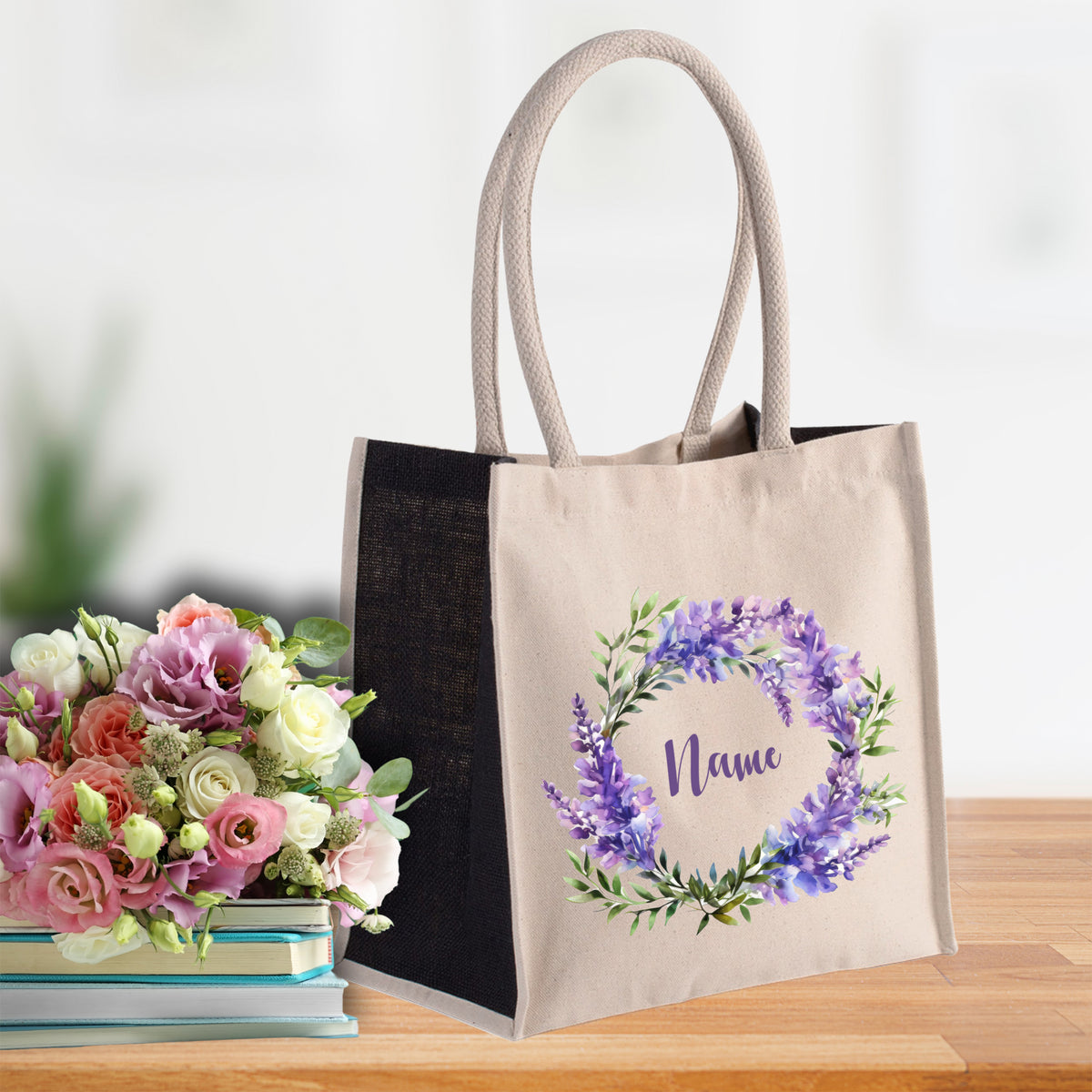 Beige Tragetasche mit lila Blumenkranz und Namen.