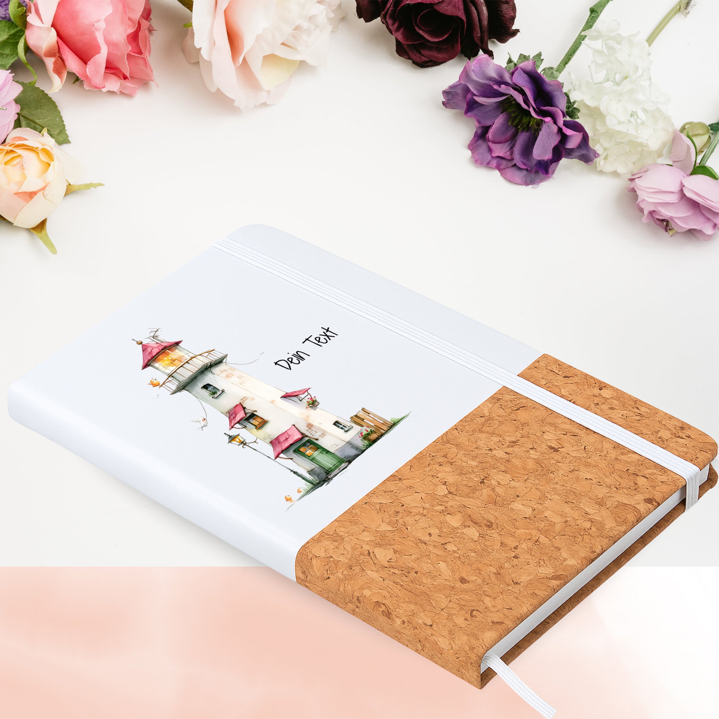 Notizbuch mit buntem Leuchtturmmotiv in Blumenarrangement