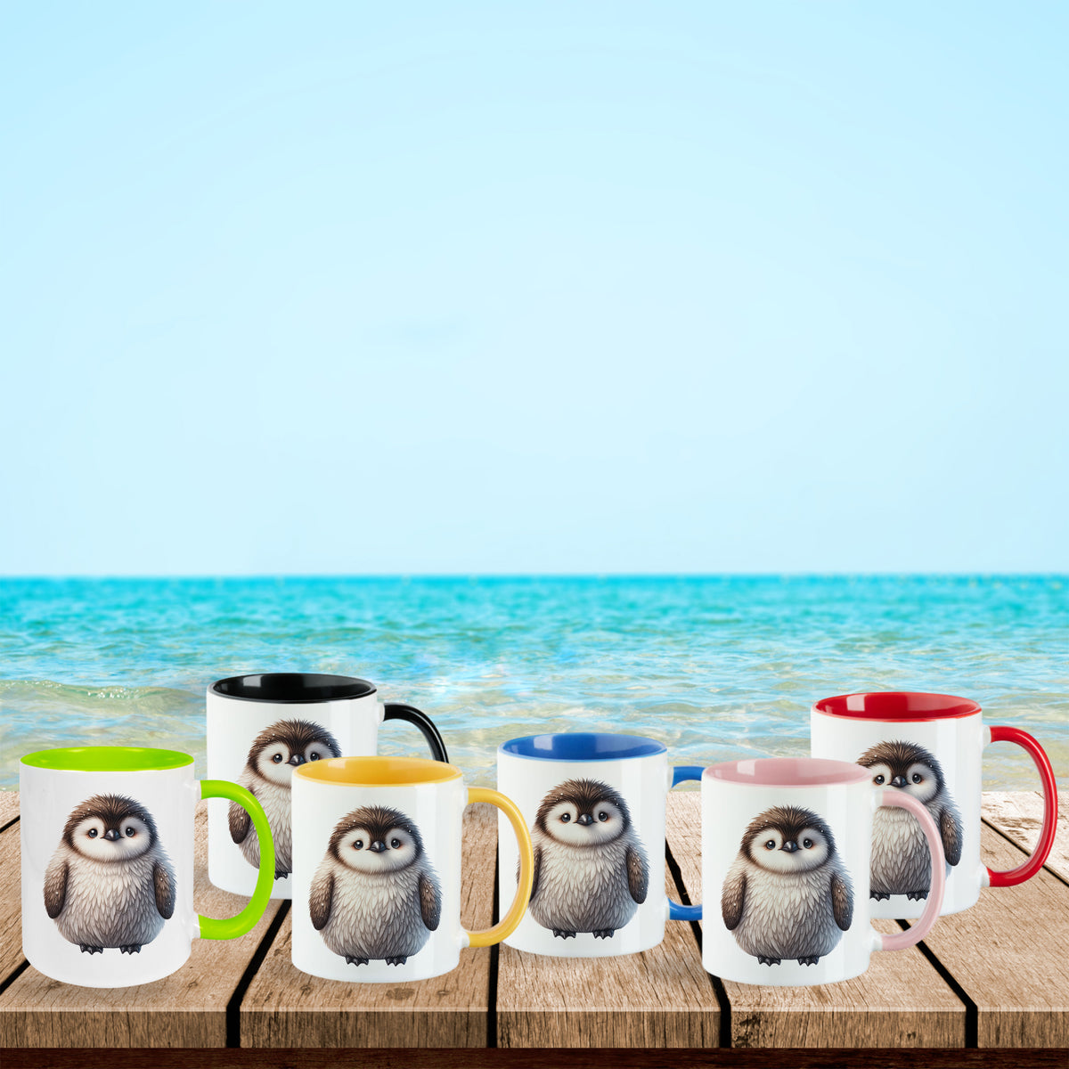 Bunte Tassen mit Pinguin-Motiv am Strand.