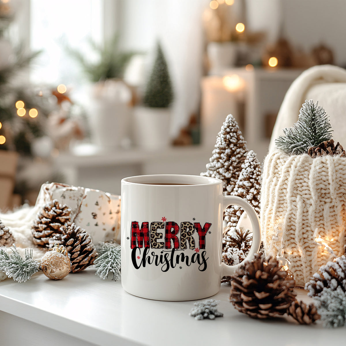 Weißer Becher mit "Merry Christmas"-Aufdruck, umgeben von Tannenzapfen.