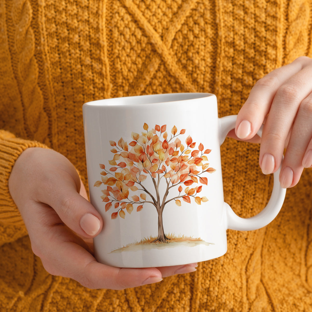 Weiße Tasse mit buntem Baum-Motiv und herbstlichen Blättern.