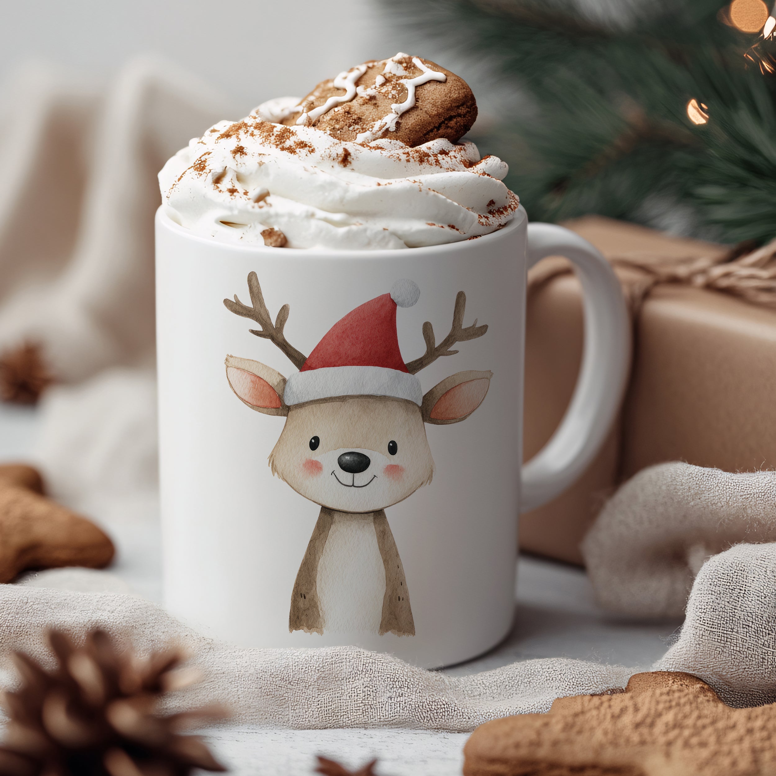 Tasse mit Rentier-Motiv, rot-weißer Weihnachtsmütze, Sahne und Plätzchen.