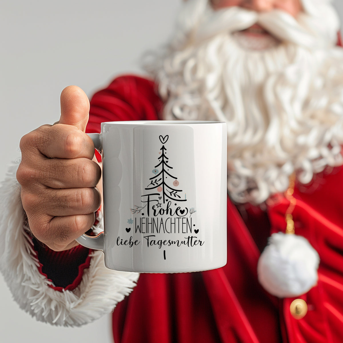 Weiße Tasse mit Weihnachtsmotiv und Text "Frohe Weihnachten".